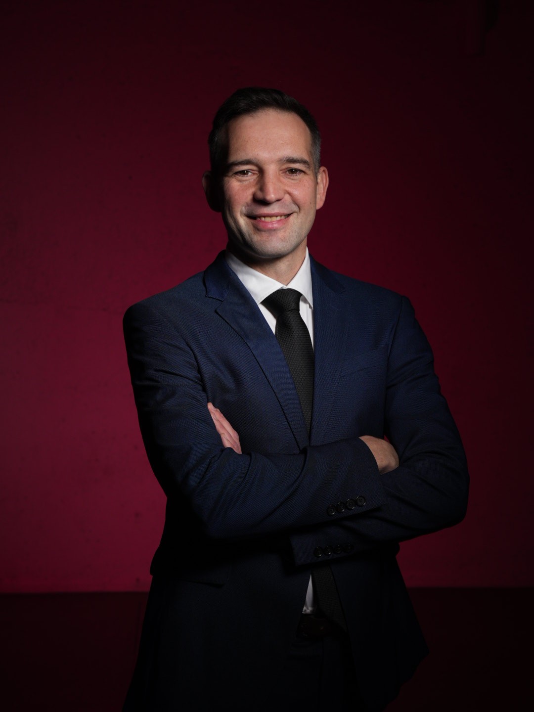 A close up of Mr. Anton, a financial expert folding his arms and smiling for Canada day