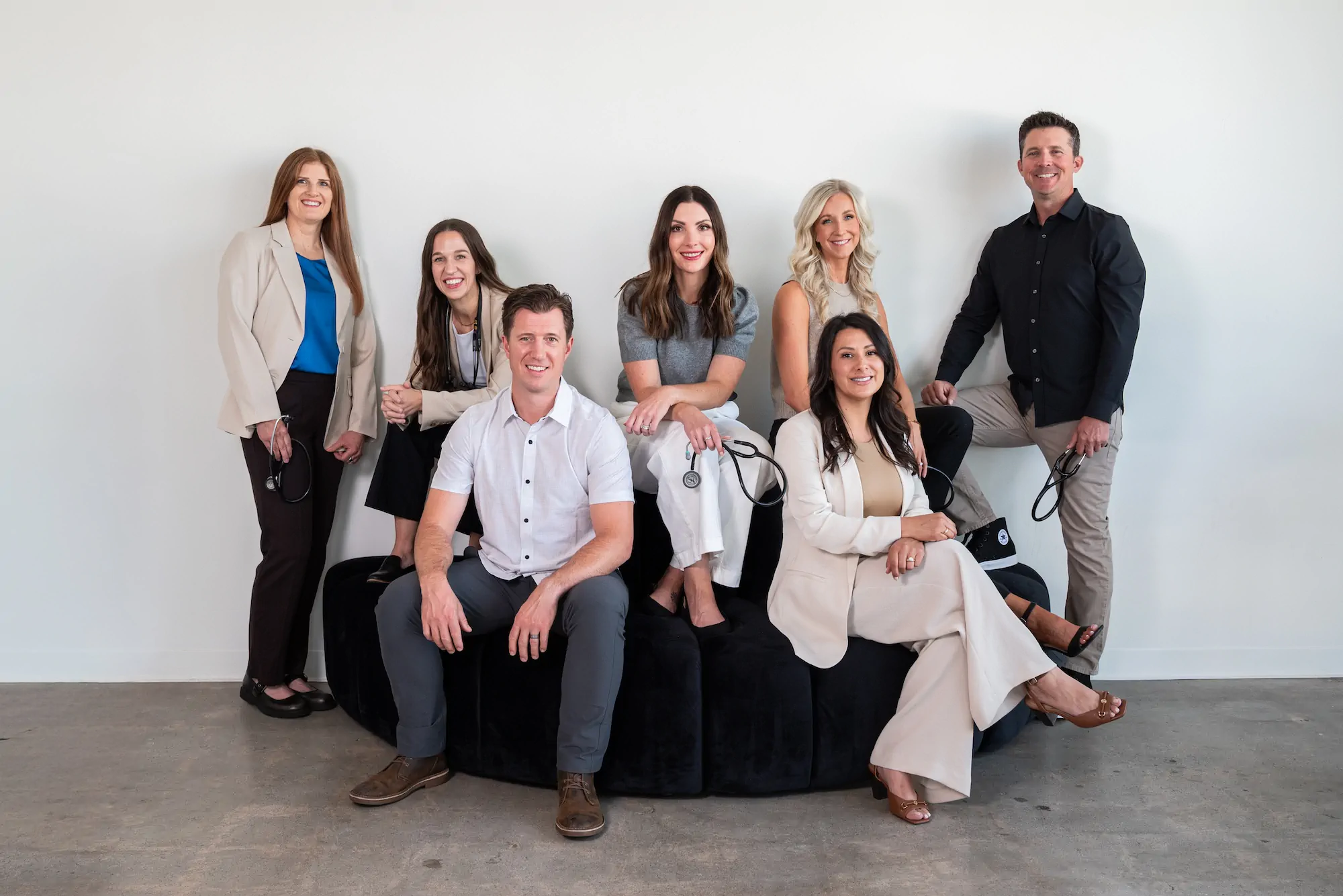 Group photo of the HRMN Health team, including Chelsey Galipeau, Jamie Ruiz, and two team members, smiling outdoors in casual attire with stethoscopes, showcasing a friendly and professional vibe.