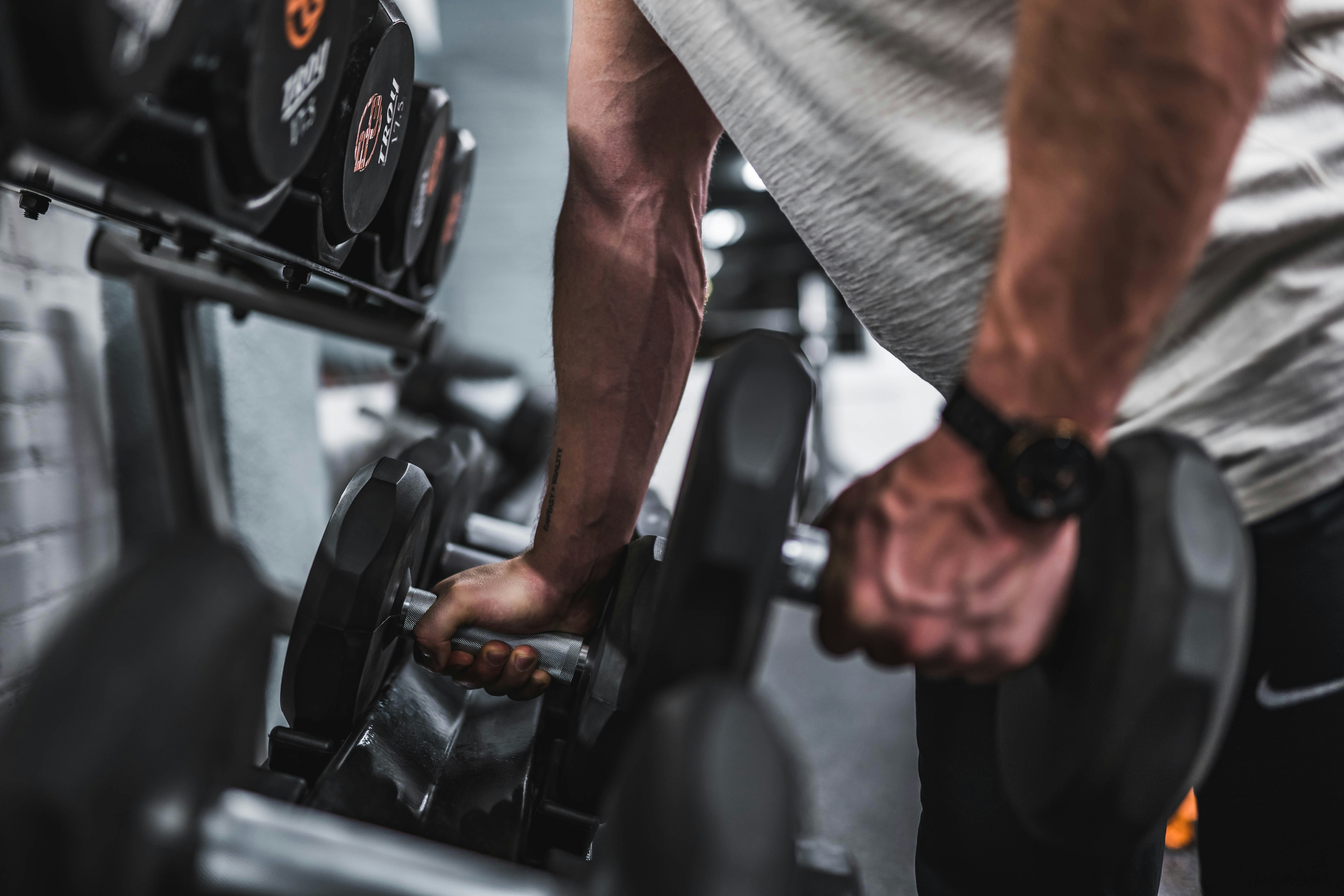 Guy grabbing dumbbells at the gym