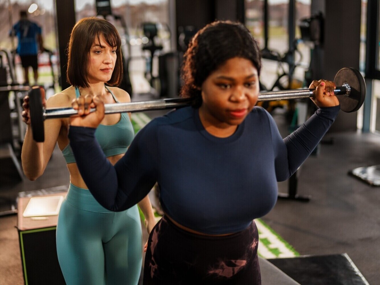 woman doing strength training with a personal trainer to complement her average steps per day for weight loss