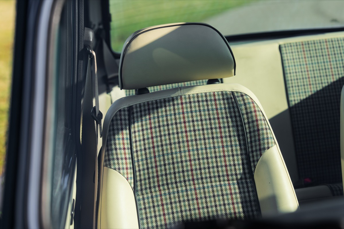Close-up of a car seat's headrest and upholstery, showcasing a neutral color and interior design.