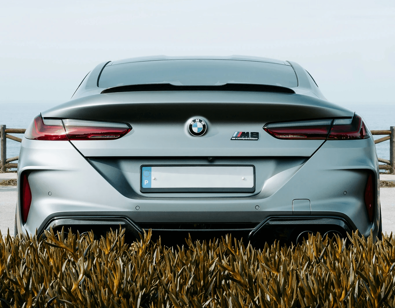 A silver car parked in a field of grass
