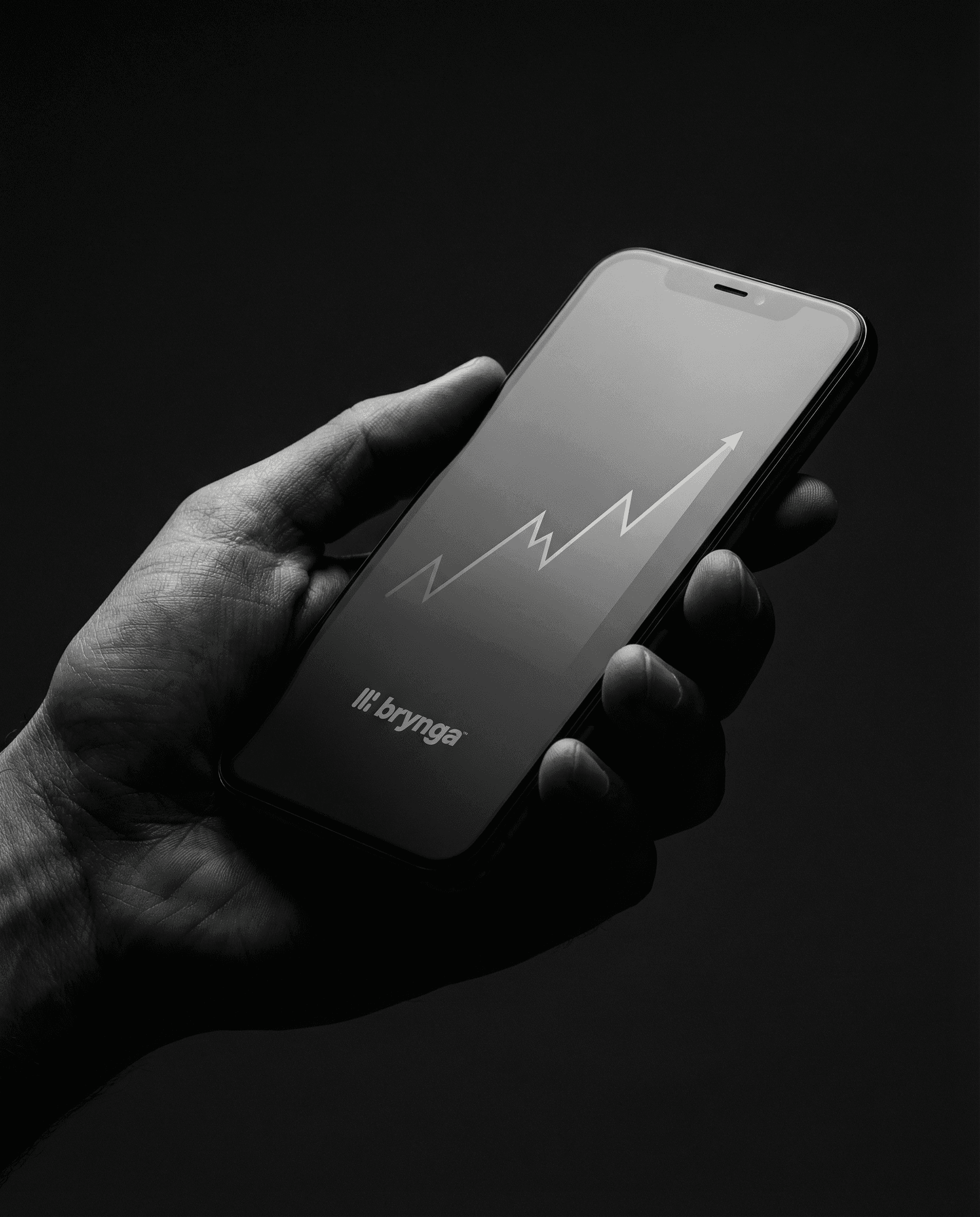 Upward trend graph in a cellphone screen held by a man's hand.