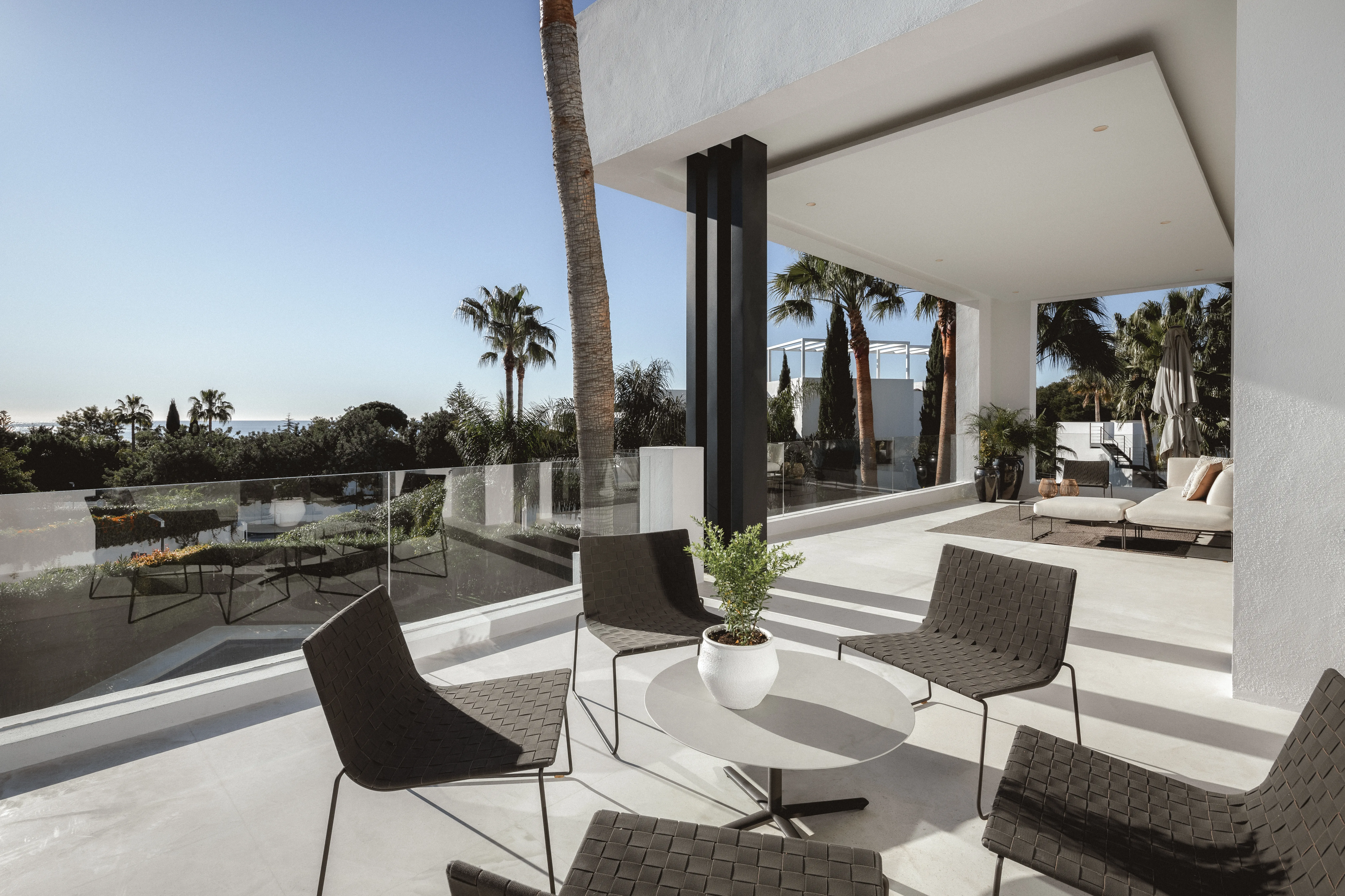 Covered outdoor lounge connecting the interior with the landscaped gardens and pool area.