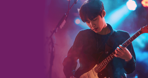 ライブステージでギターを弾いている男性