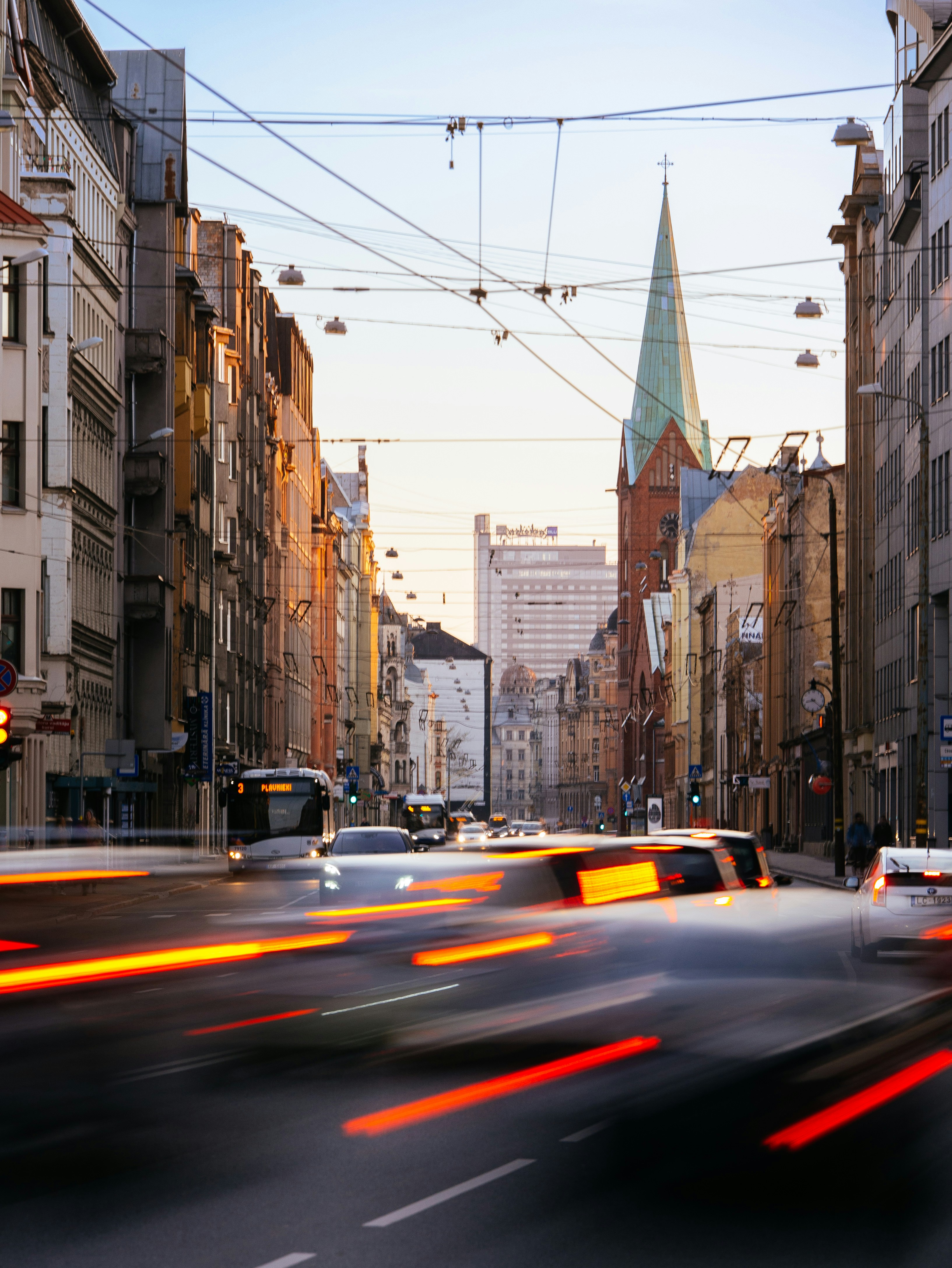 cars on road between high rise buildings during daytime