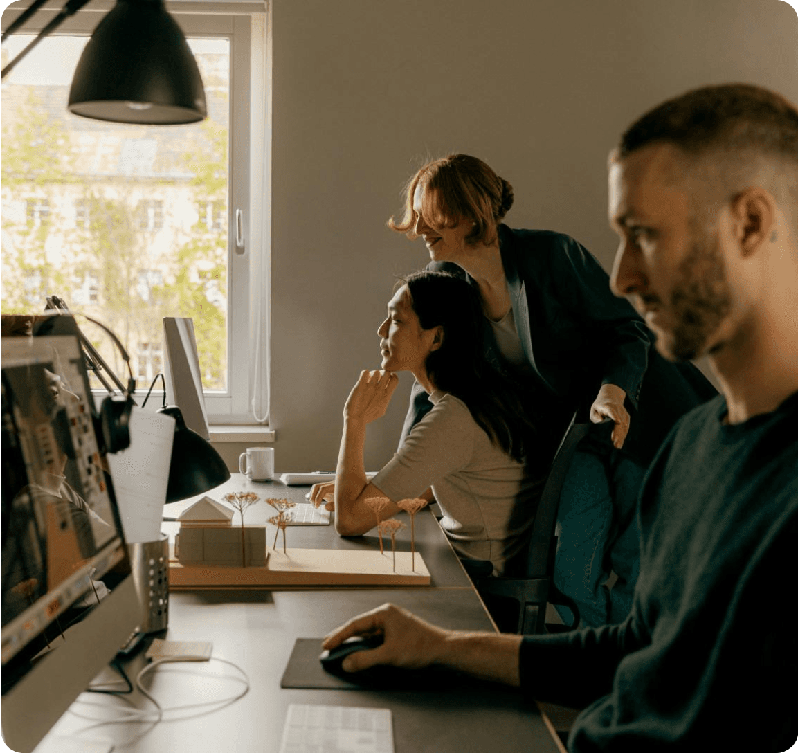 A diverse group of professionals collaborating on a computer in a modern office environment