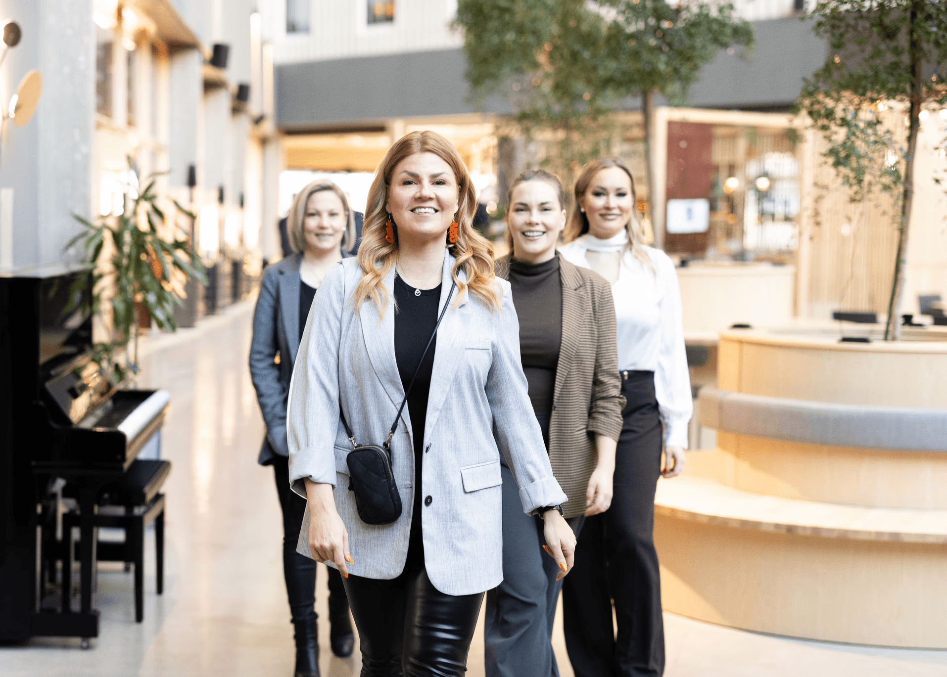 Network & Growthin valmentajatiimi kävelee yhdessä modernissa toimistotilassa.