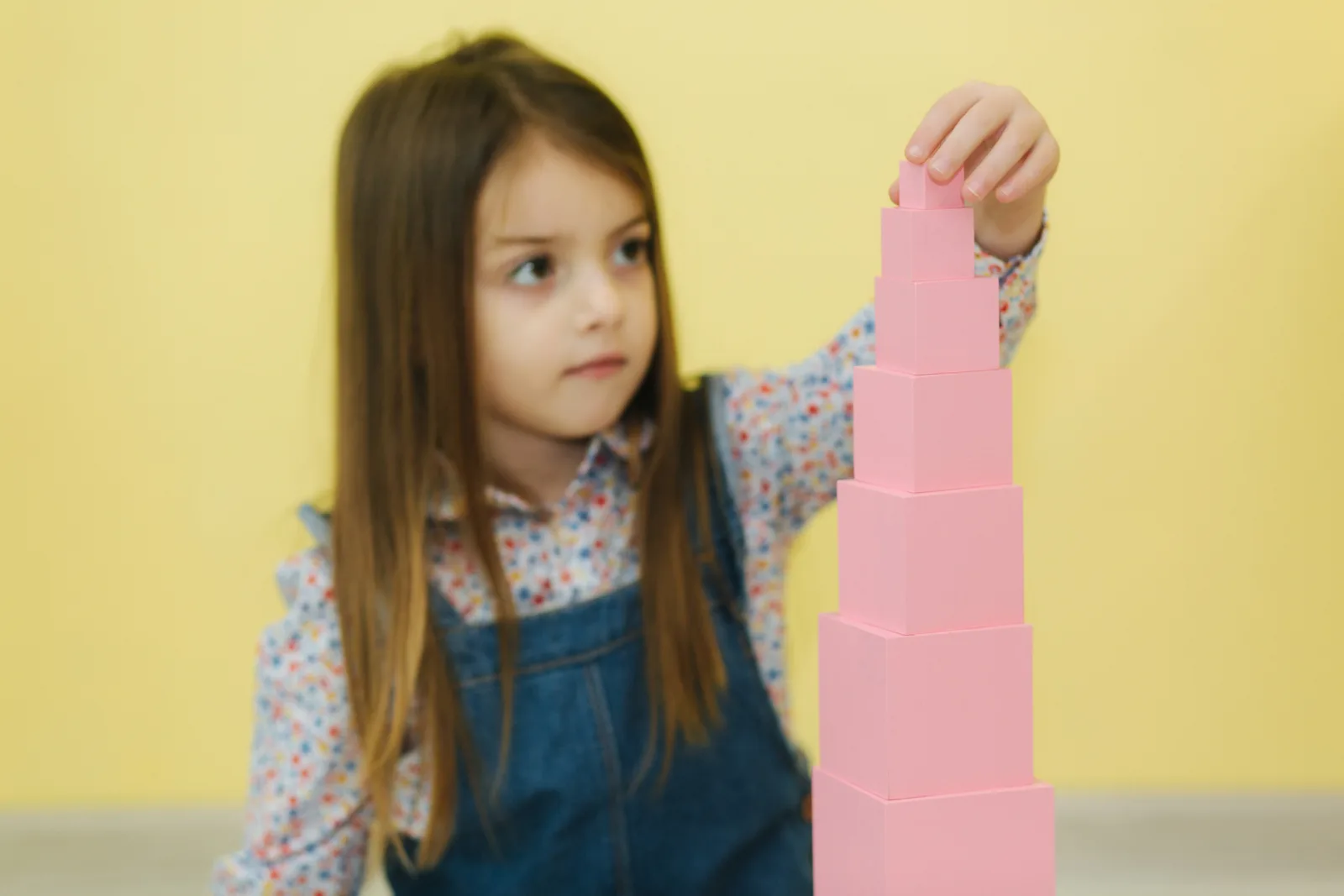 Enfant construisant la tour rose Montessori