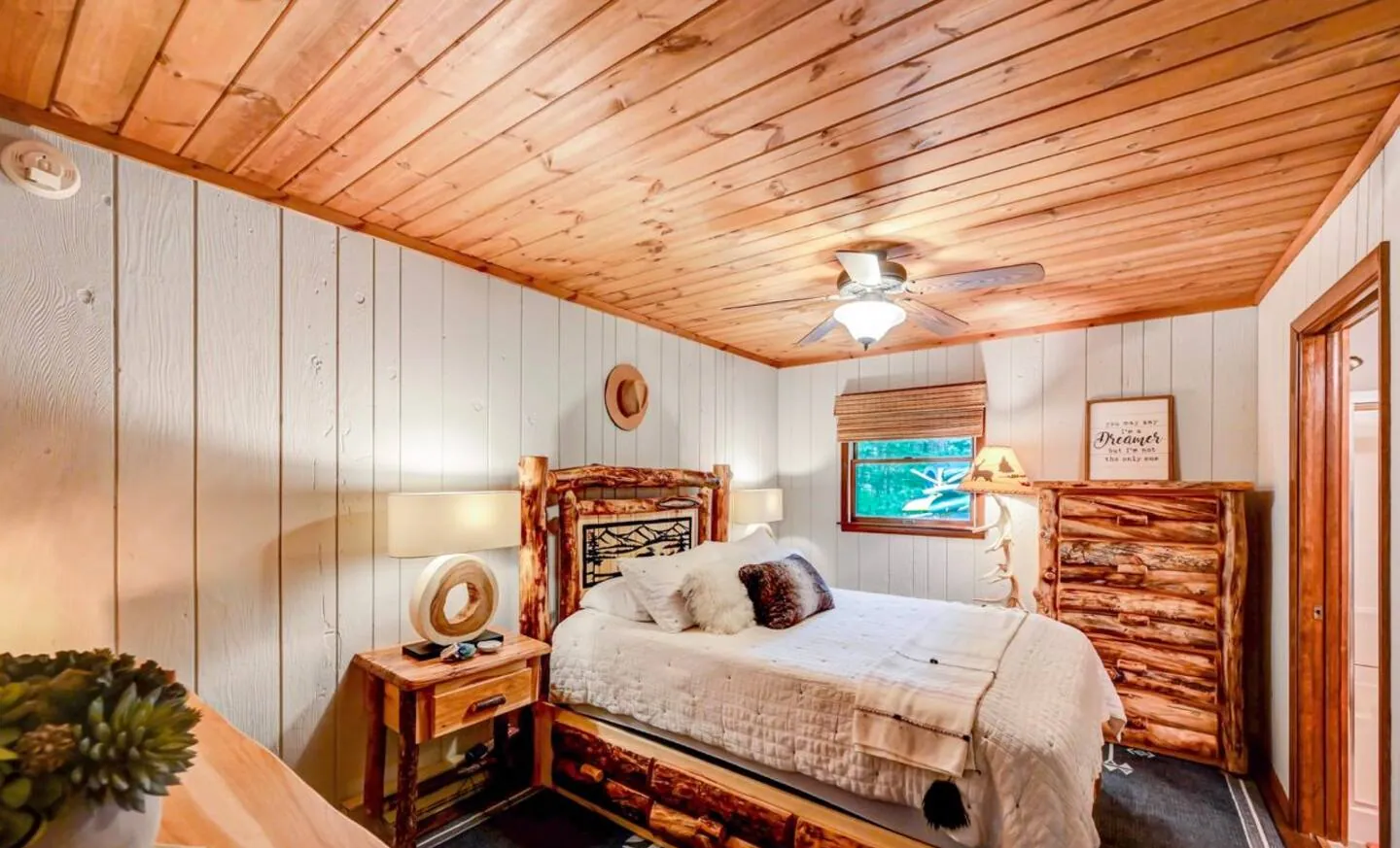 Queen bedroom with log bed, dresser and en suite door at Mountain MAMA