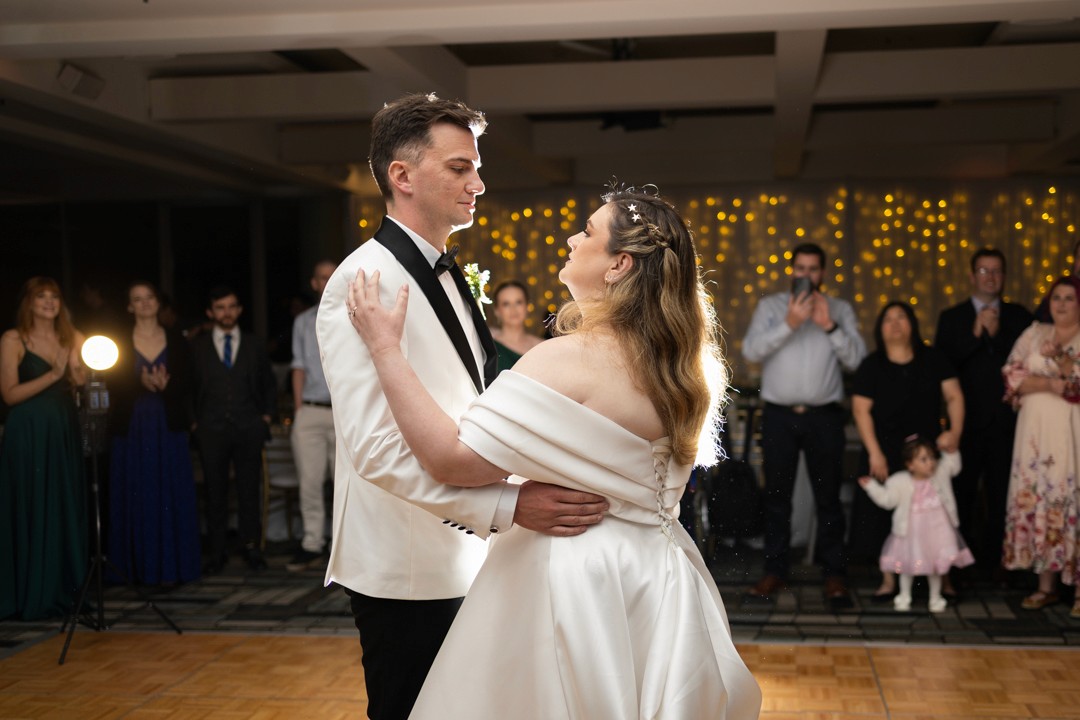 Bride and groom first dance in front of guests
