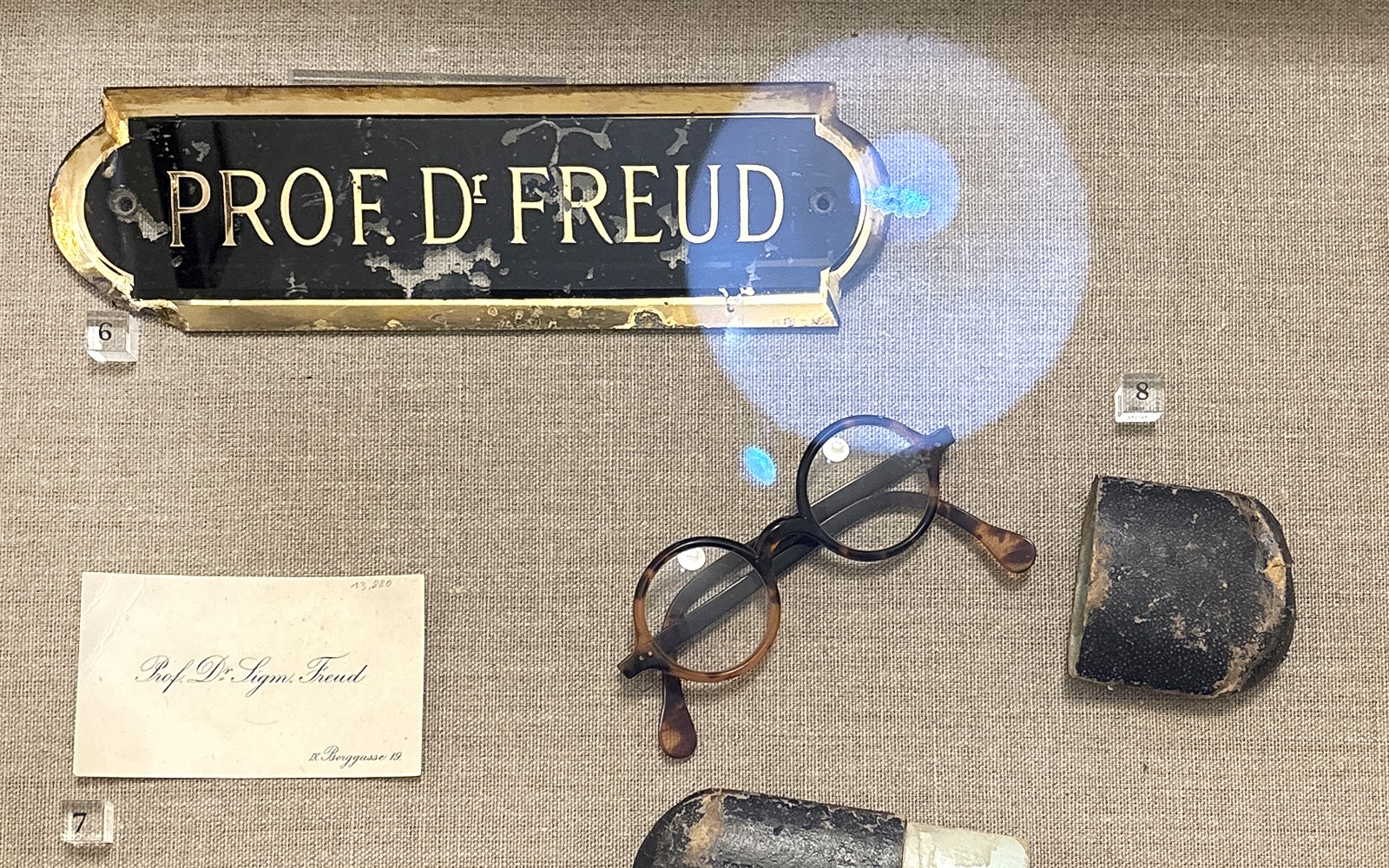 Papan nama Sigmund Freud, kacamata, dan barang-barang pribadi di Museum Sigmund Freud.