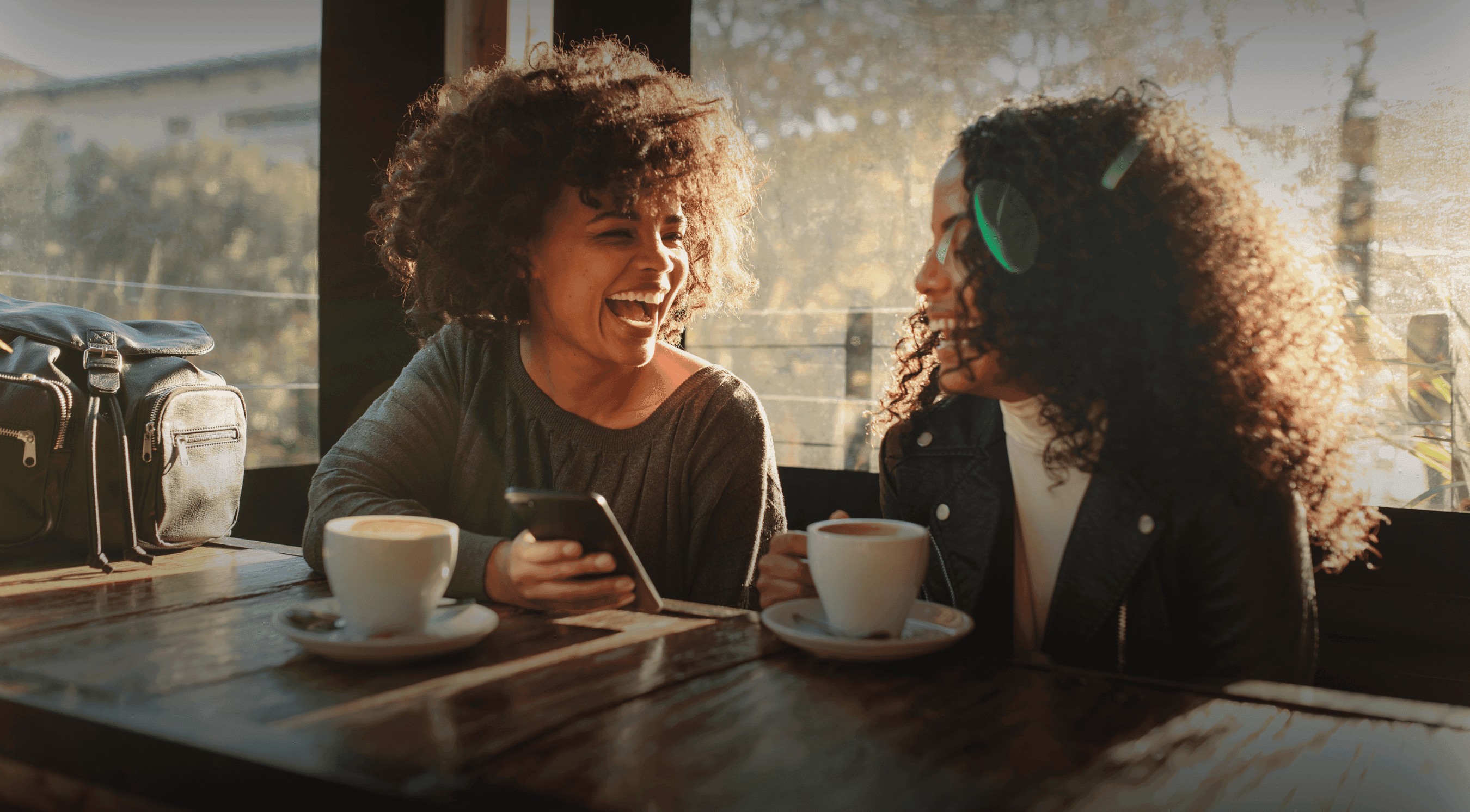 Two young black women enjoying a discussion over coffee