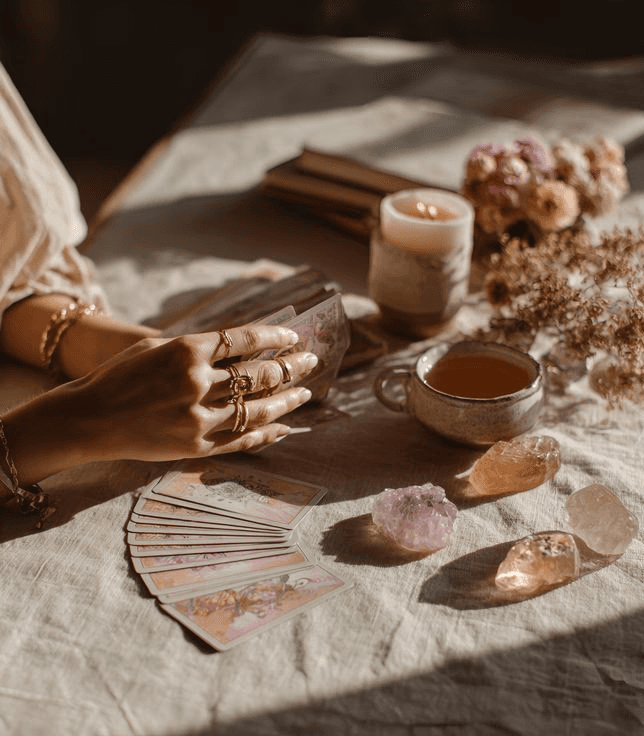 A person with curly hair sits at a desk, working on a laptop in a cozy, well-lit environment.