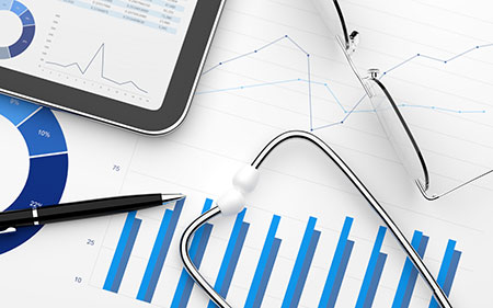 Stethoscope over line charts & tablet with marketing data