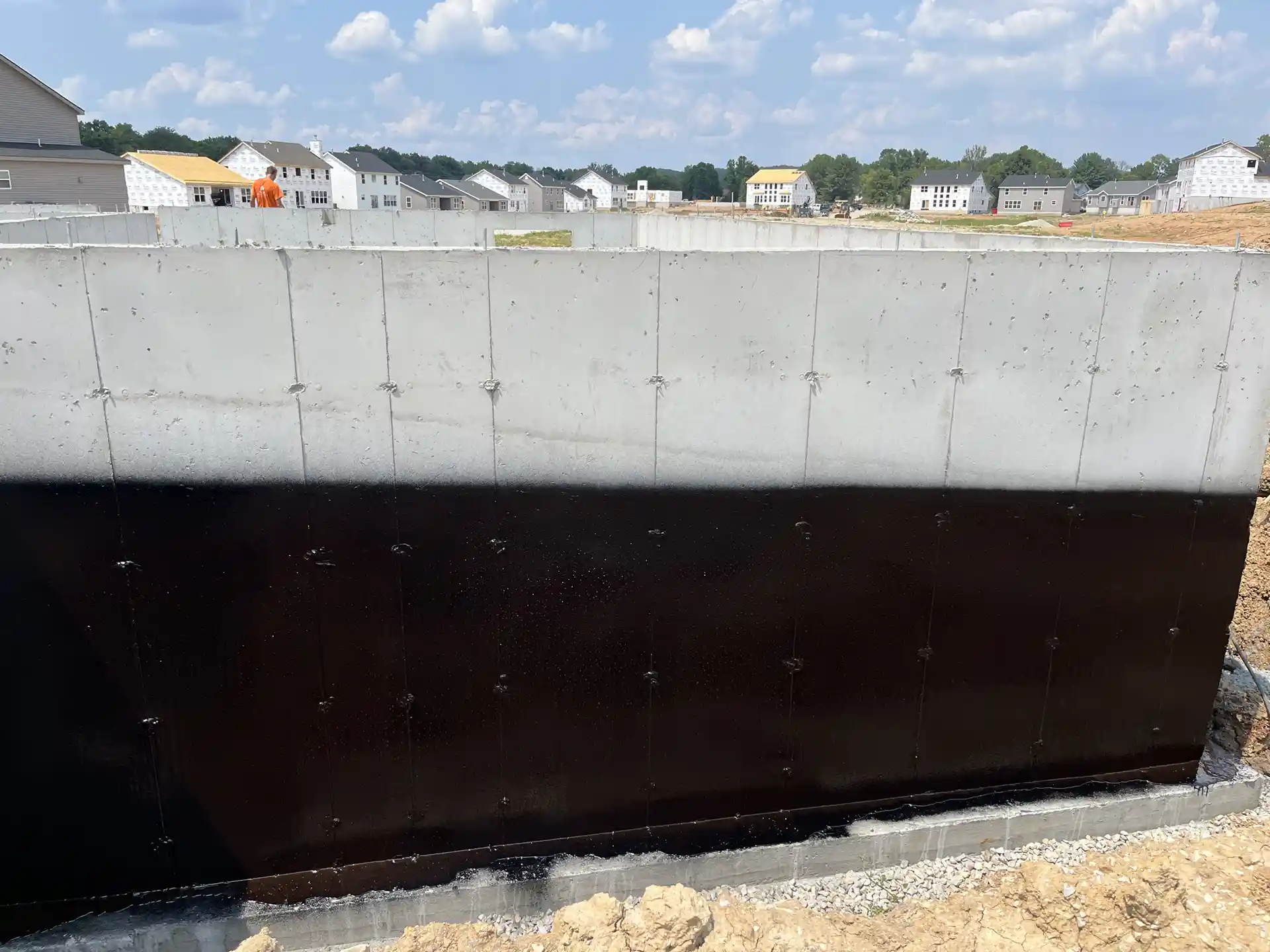 New home construction concrete foundation with black Rub-R-Proof waterproof coating applied