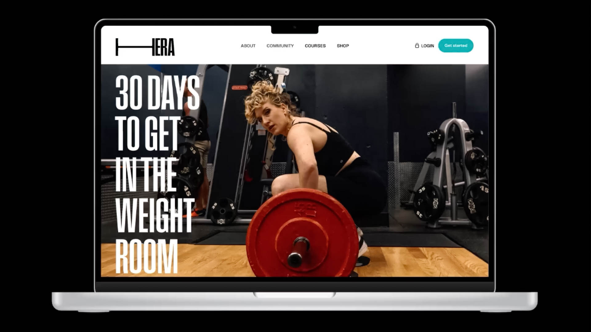 A laptop screen displays a fitness website with a woman lifting a red weight on a barbell. The website features the text "30 DAYS TO GET IN THE WEIGHT ROOM" and a logo with the letters "HERA." A "GET STARTED" button is visible in the top right corner. The background shows a gym setting with exercise equipment.