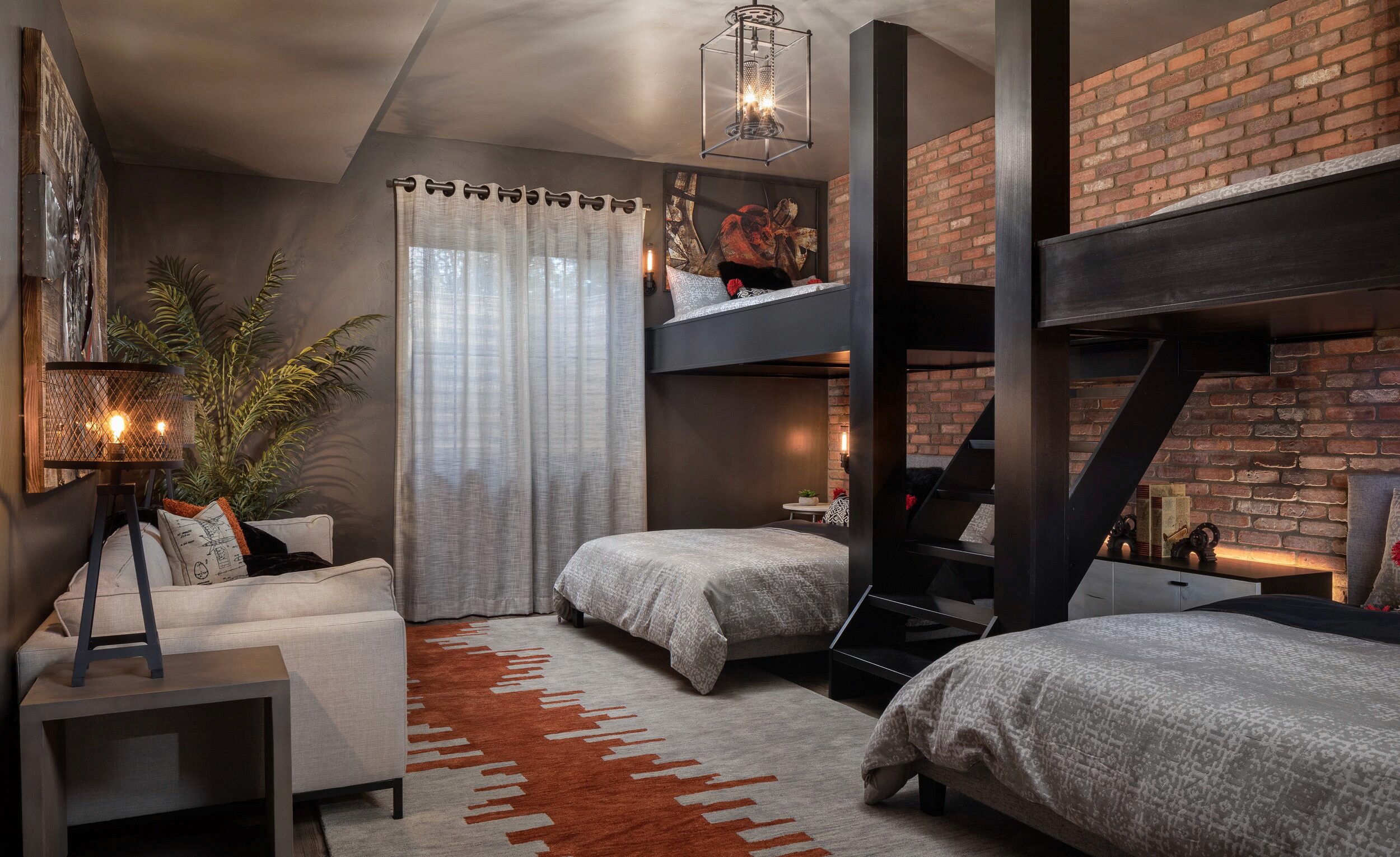 Bunk beds in a room with brick wall and sofa