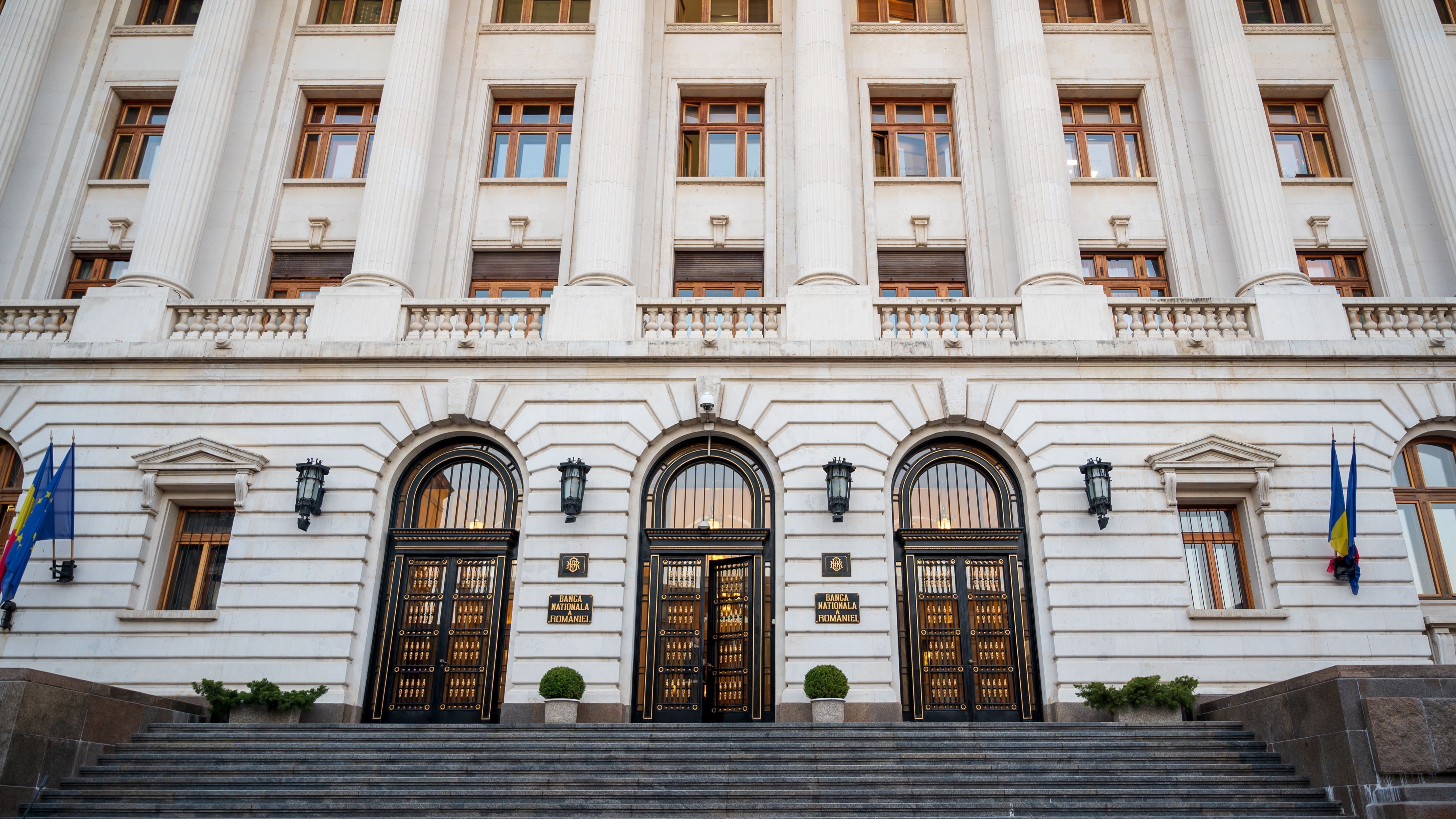 Voorgevel van een gebouw met drie grote bogen en decoratieve architectonische details.
