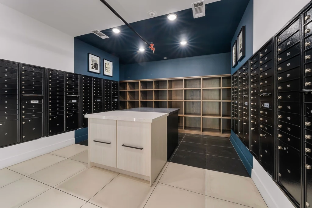 Mail and package room at the post office, featuring shelves filled with various packages and organized mail bins.