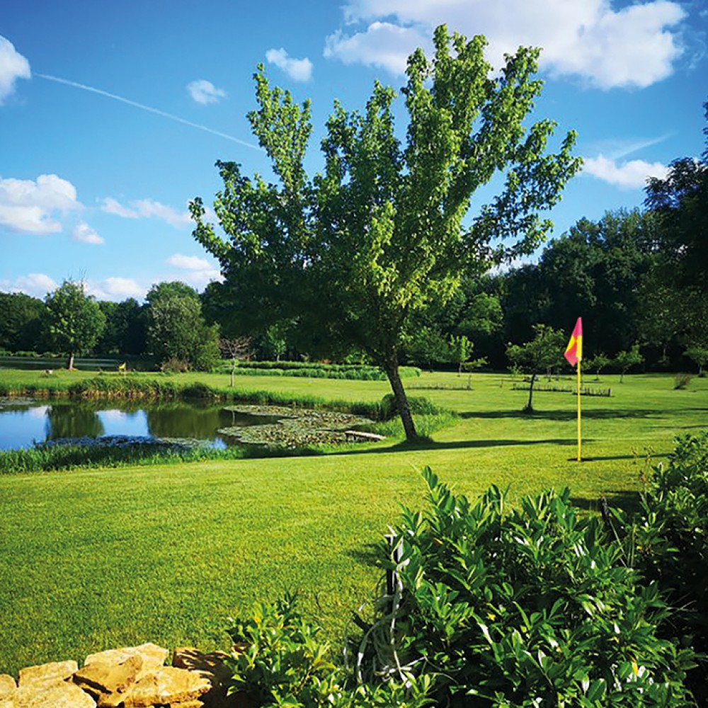 Jolie vue du parcours de foot golf du domaine de la brame, le ciel est bleu et l'herbe fraîchement tondue