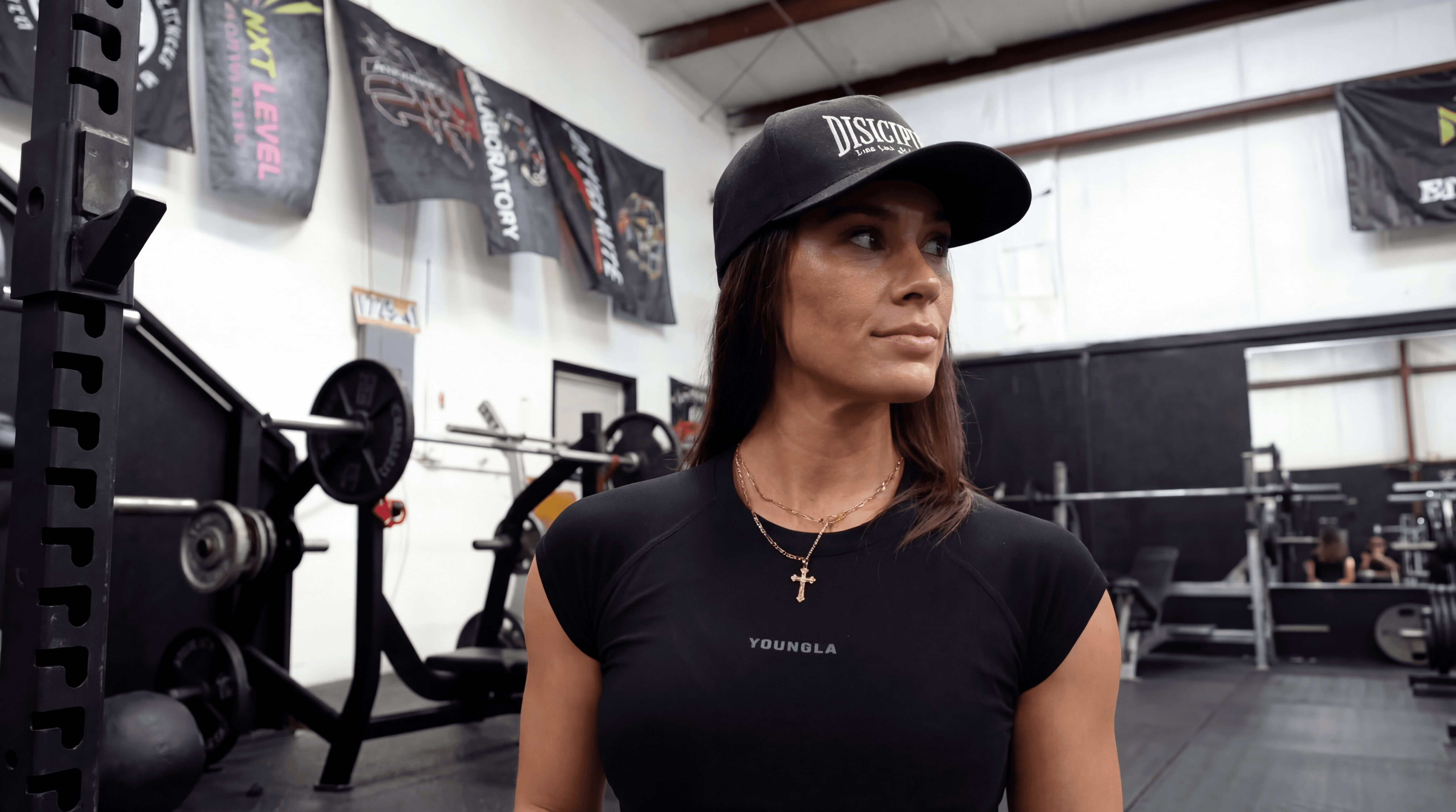 Rachel, personal trainer, looking to the side confidently in a fitness studio