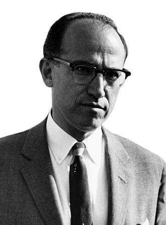 A black-and-white photograph of a man wearing a suit, tie, and glasses, with a serious expression, likely taken in the mid-20th century. His receding hairline and classic, professional attire give the image a historical and scholarly feel. The background includes part of an airplane, suggesting a context related to travel or an event.