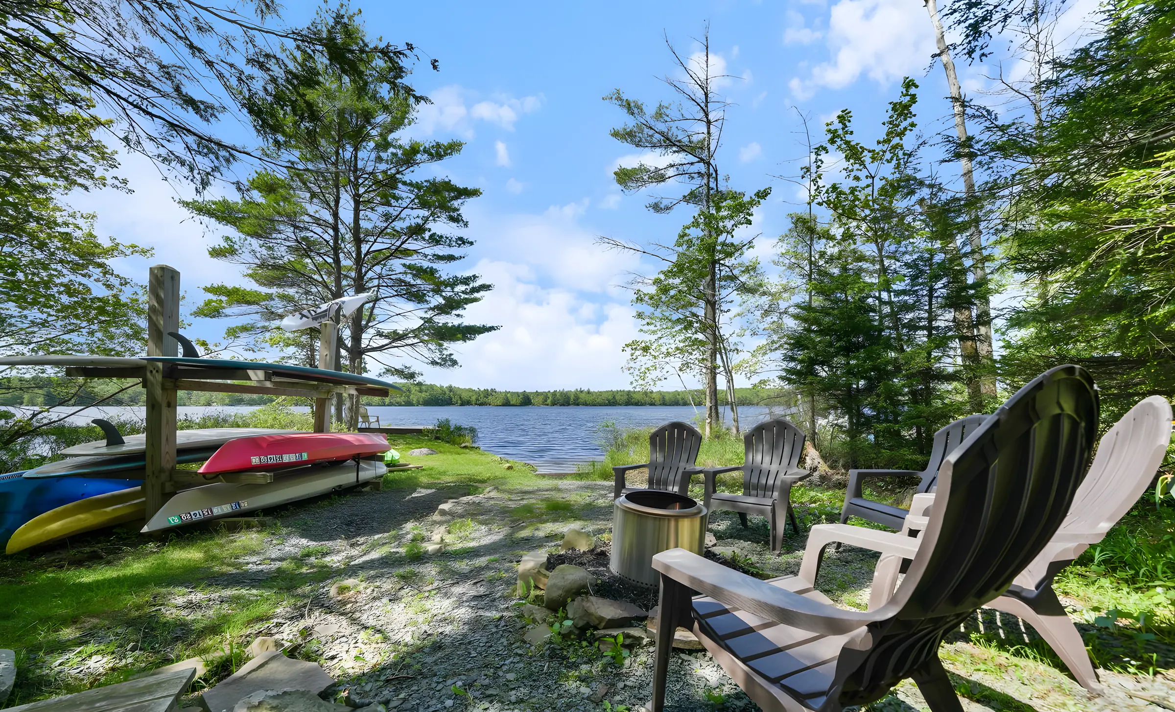 Lakefront fire pit seating with kayaks and paddleboards at Lake Front, Lake Naomi, Pocono Pines, PA