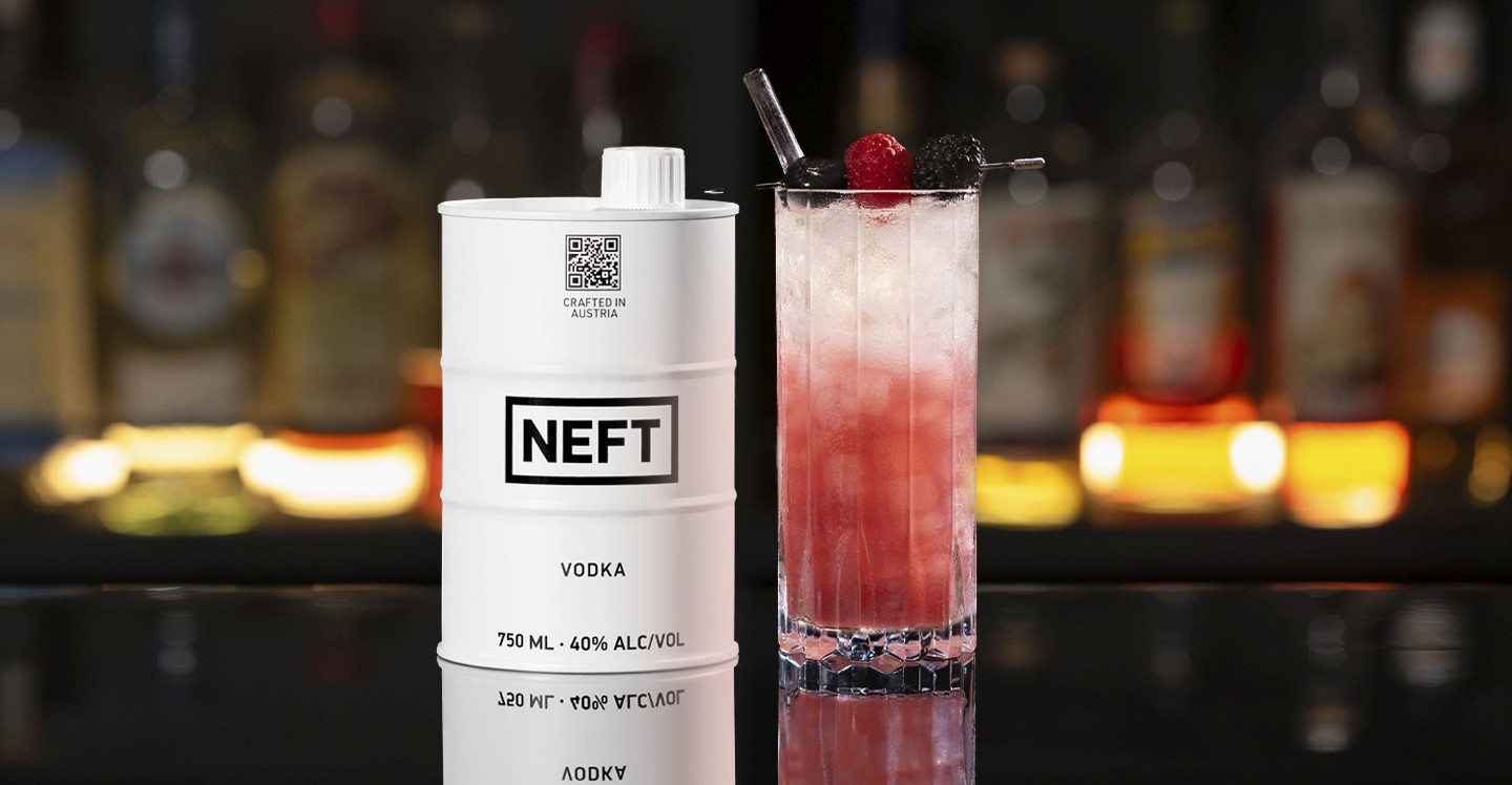 A NEFT Barrel and a glass of Almond Berry Spritz on a bar counter.