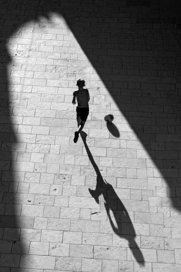 Kid playing soccer on the Dubrovnik streets