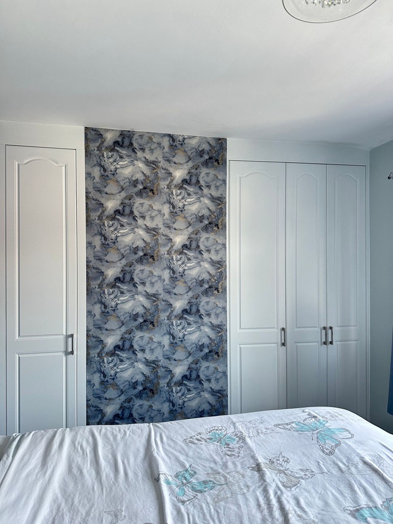 white wardrobe in room with blue pattern wall
