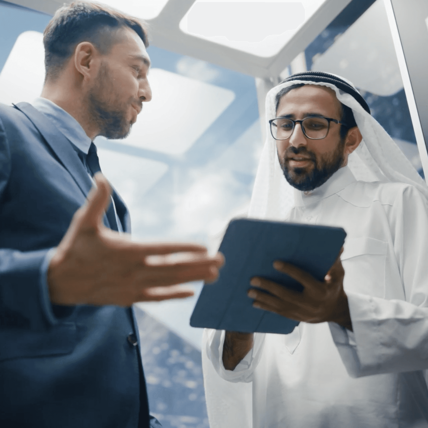 Arab Financial Services executives reviewing fintech strategy on tablet, symbolizing trust and digital agility