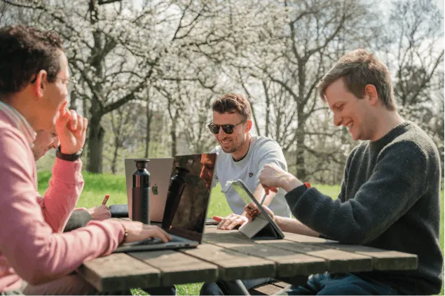 Drie astro experts die buiten aan een picknick tafel zitten