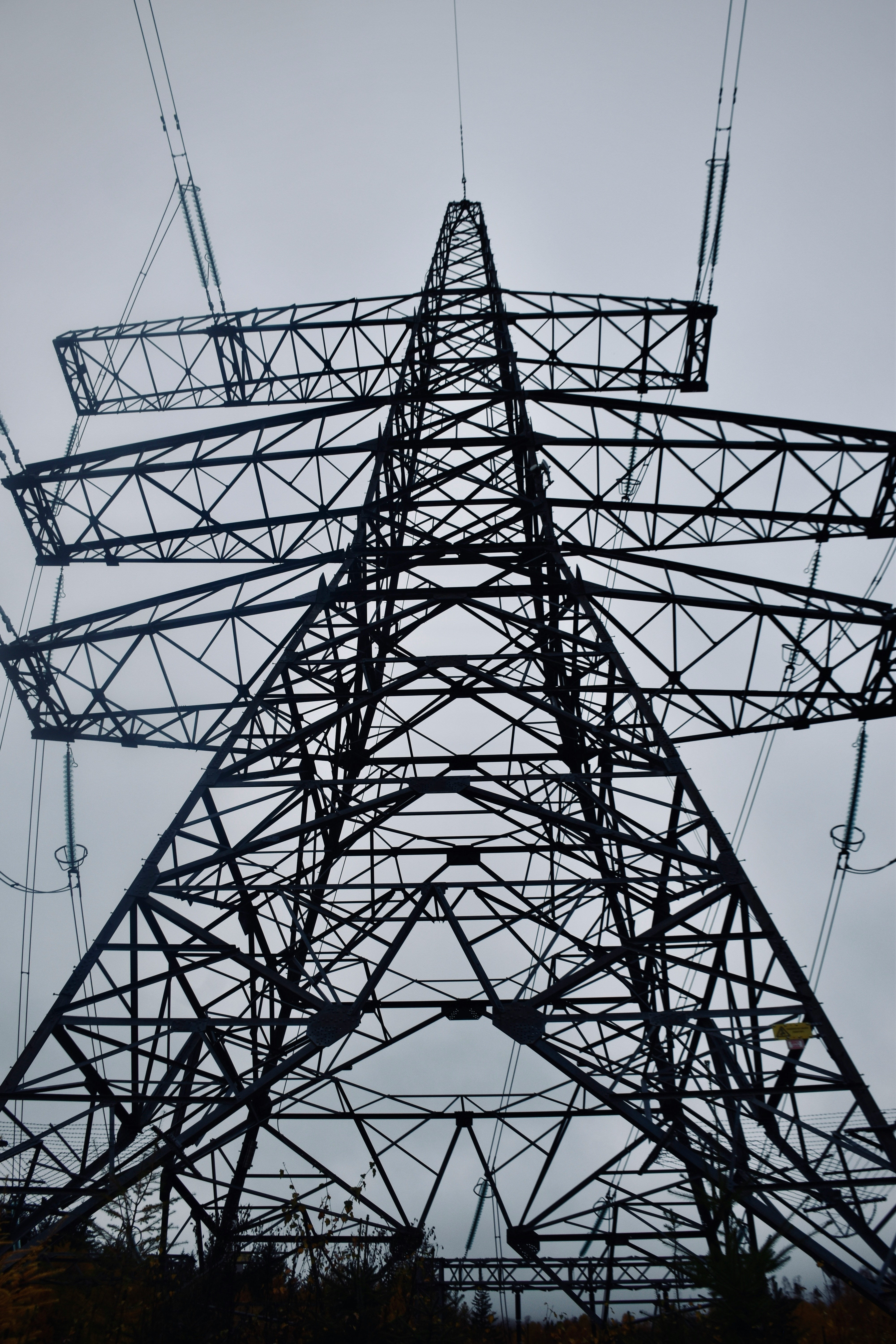 A tall metal tower with lots of wires above it