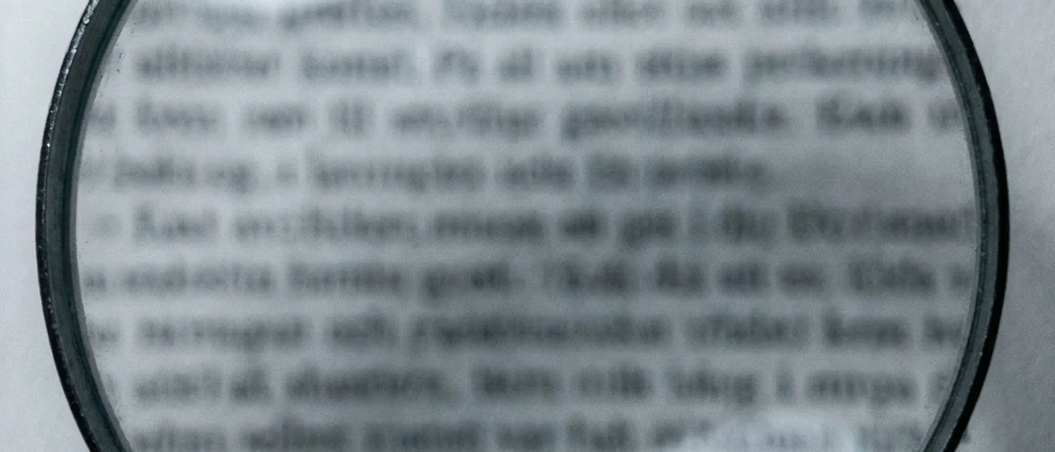 Magnifying glass over blurred text.