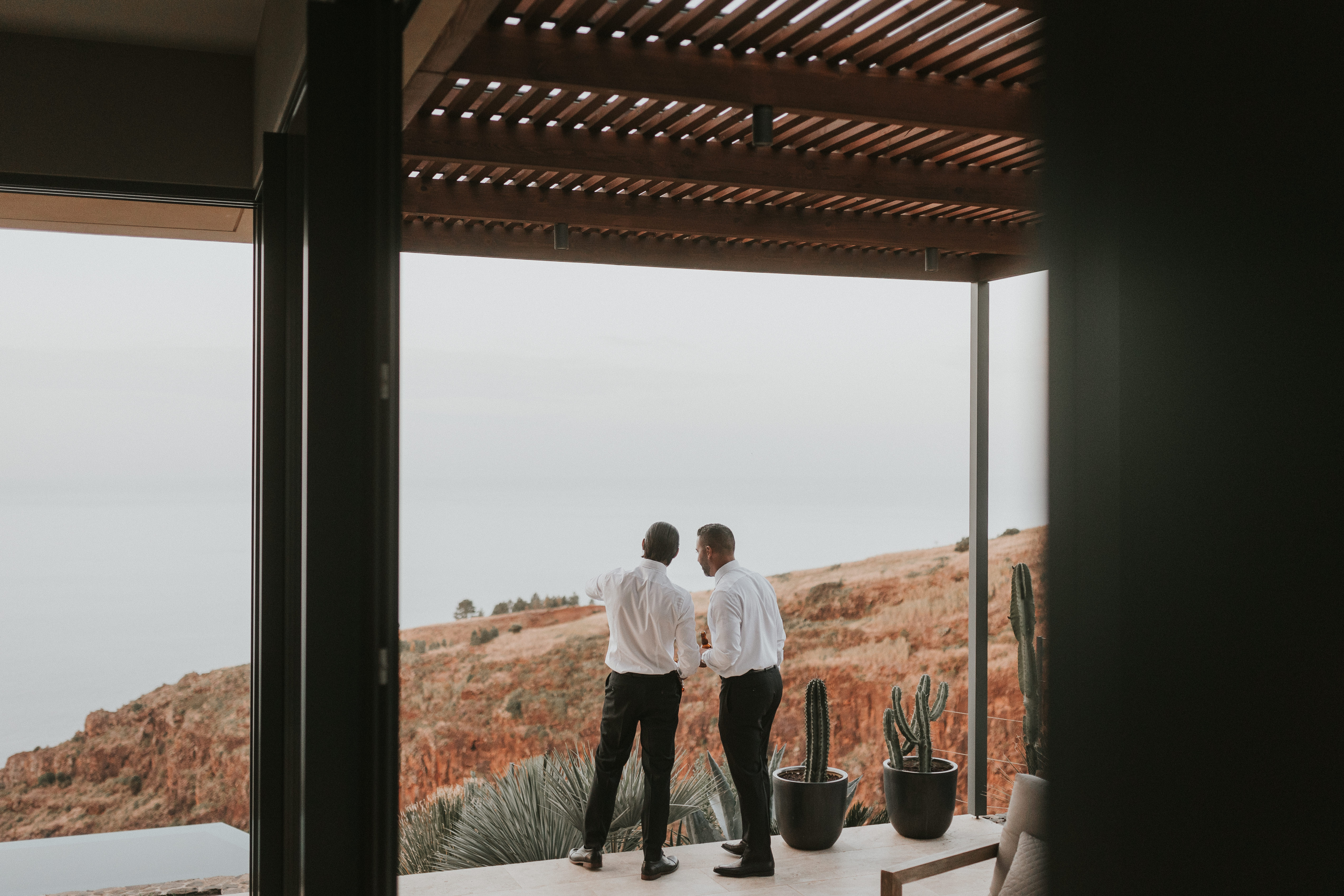 Groom and groomsman enjoying dramatic ocean views together