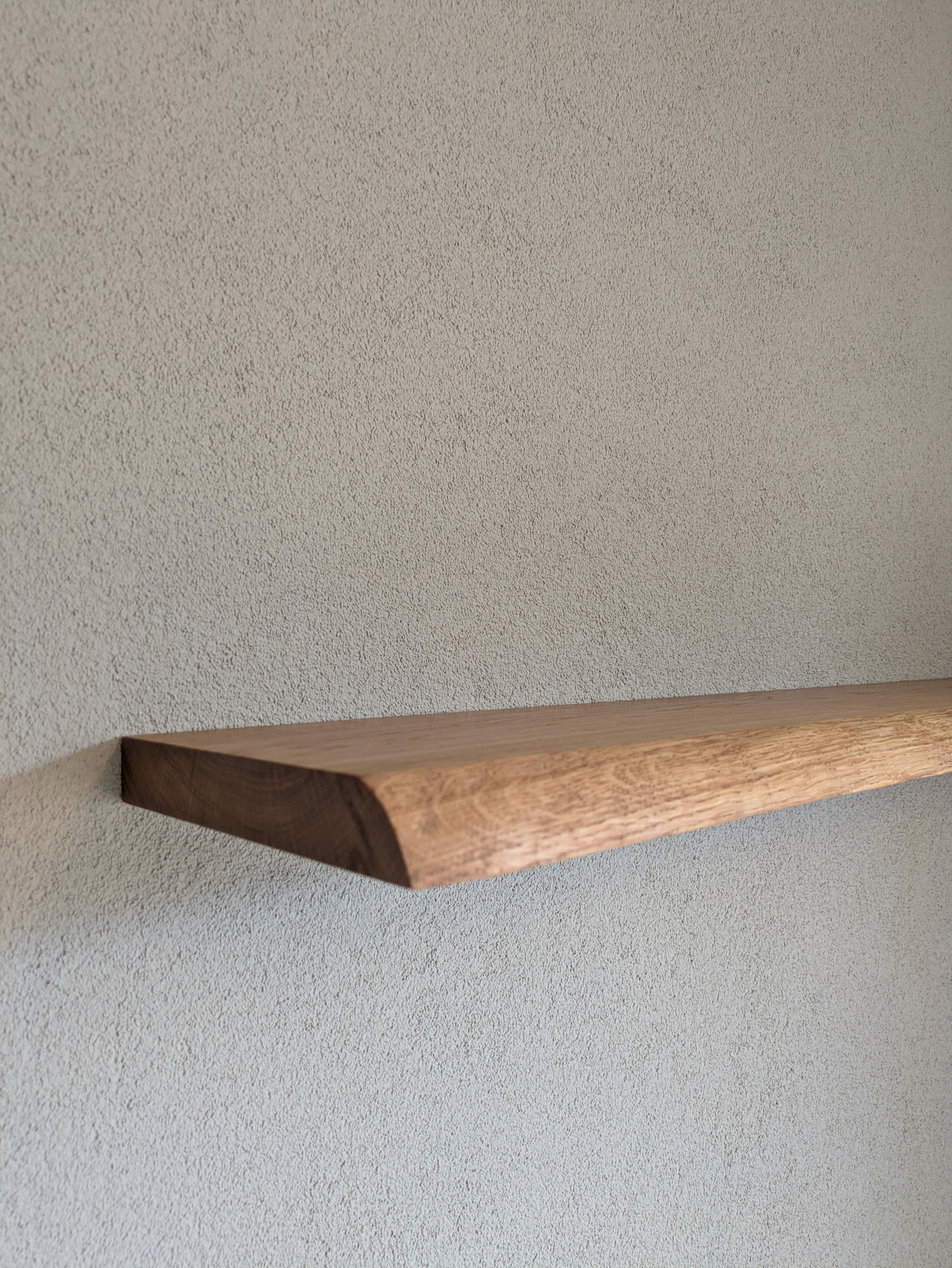 Handgemaakte eikenhouten wandplank met een natuurlijke afronding in de voorste rand