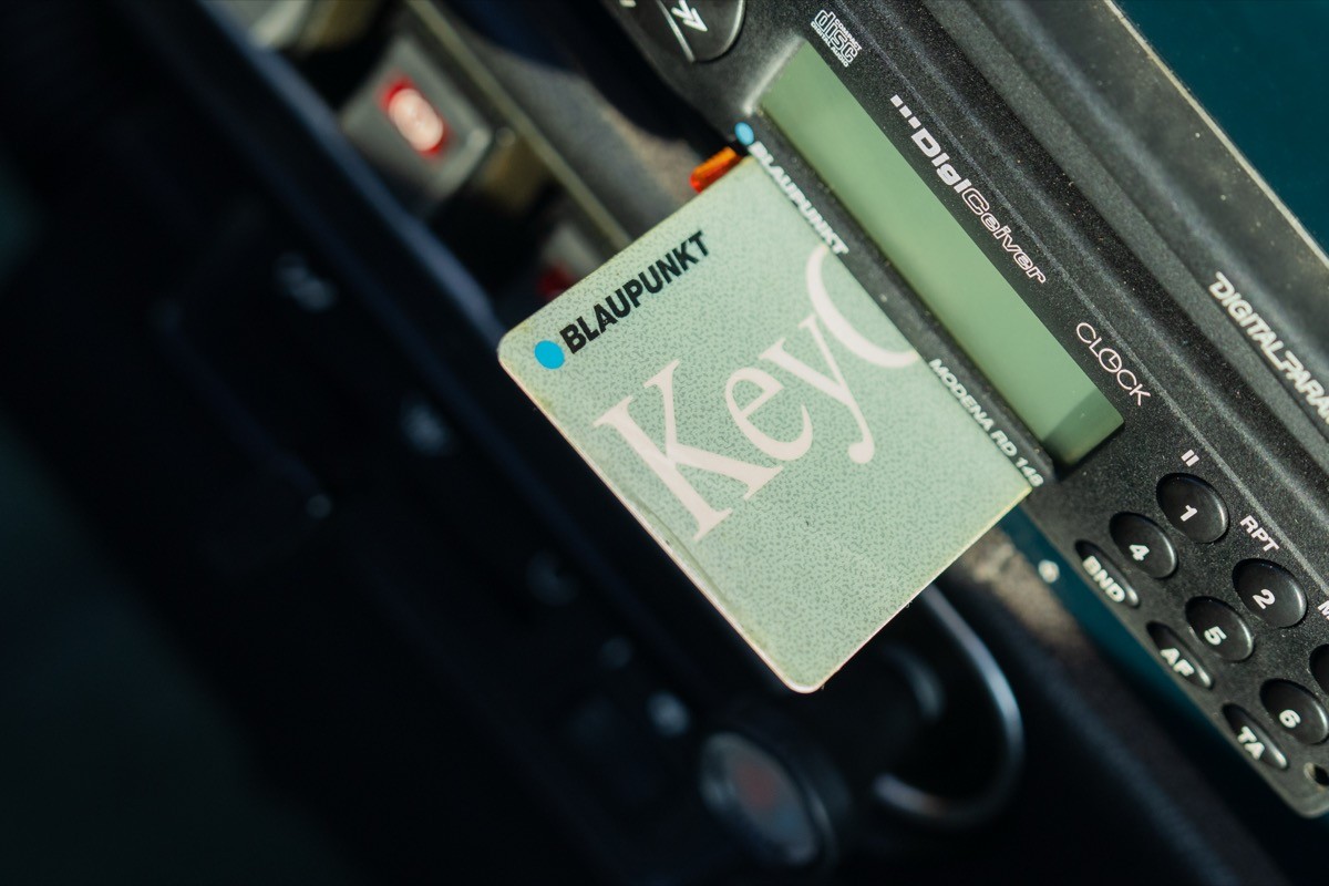 A close-up view of a green notebook resting on a textured surface, with a blurred background.