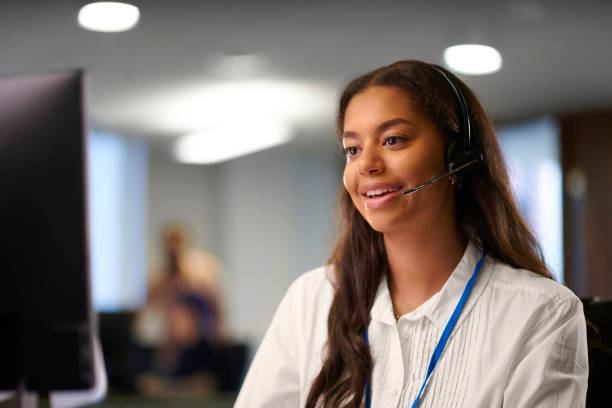 customer service woman wearing a headset smiling with office in background