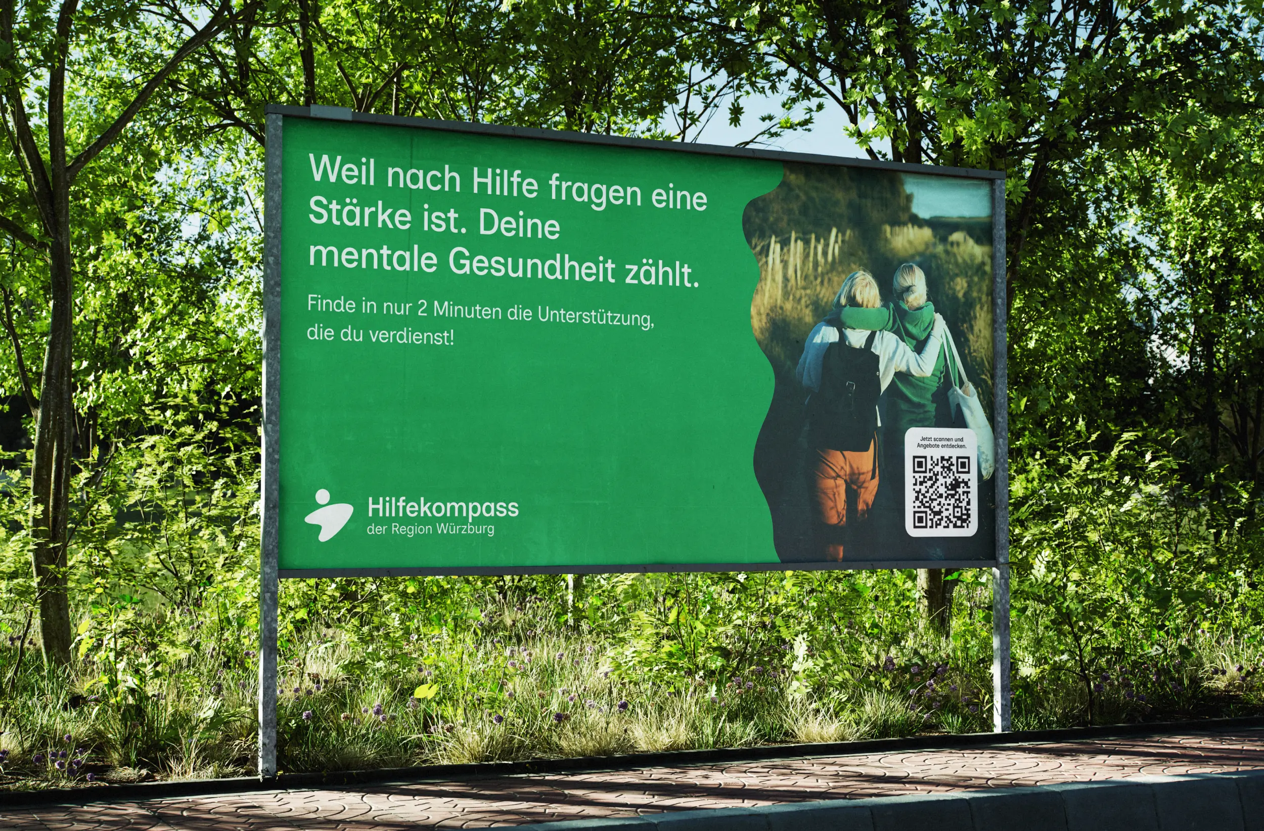 Plakatmockup zum Hilfekompass mit Headline zur mentalen Gesundheit und Foto von zwei Menschen auf einer Wiese.