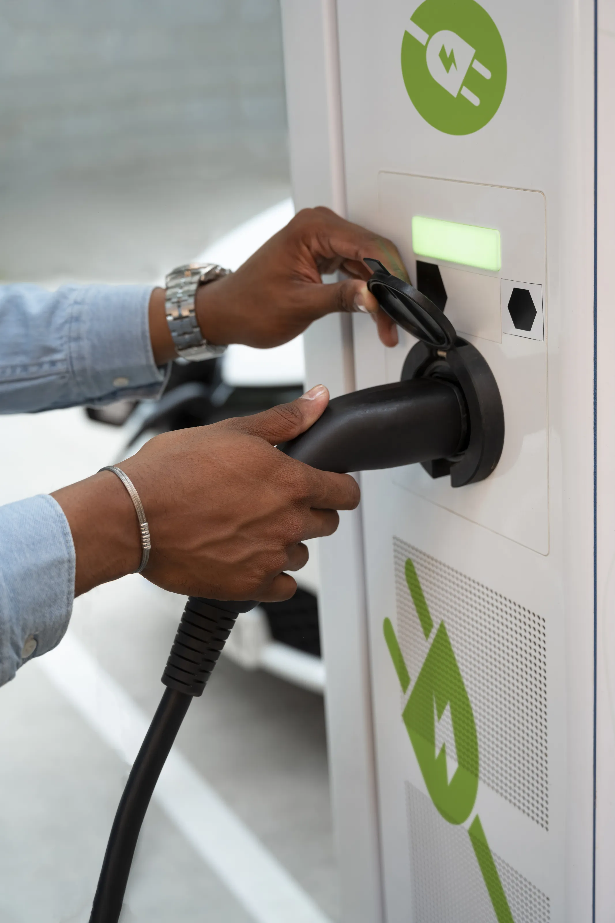 Resident plugging in electric vehicle at the EV charging station at Cocoon 121.