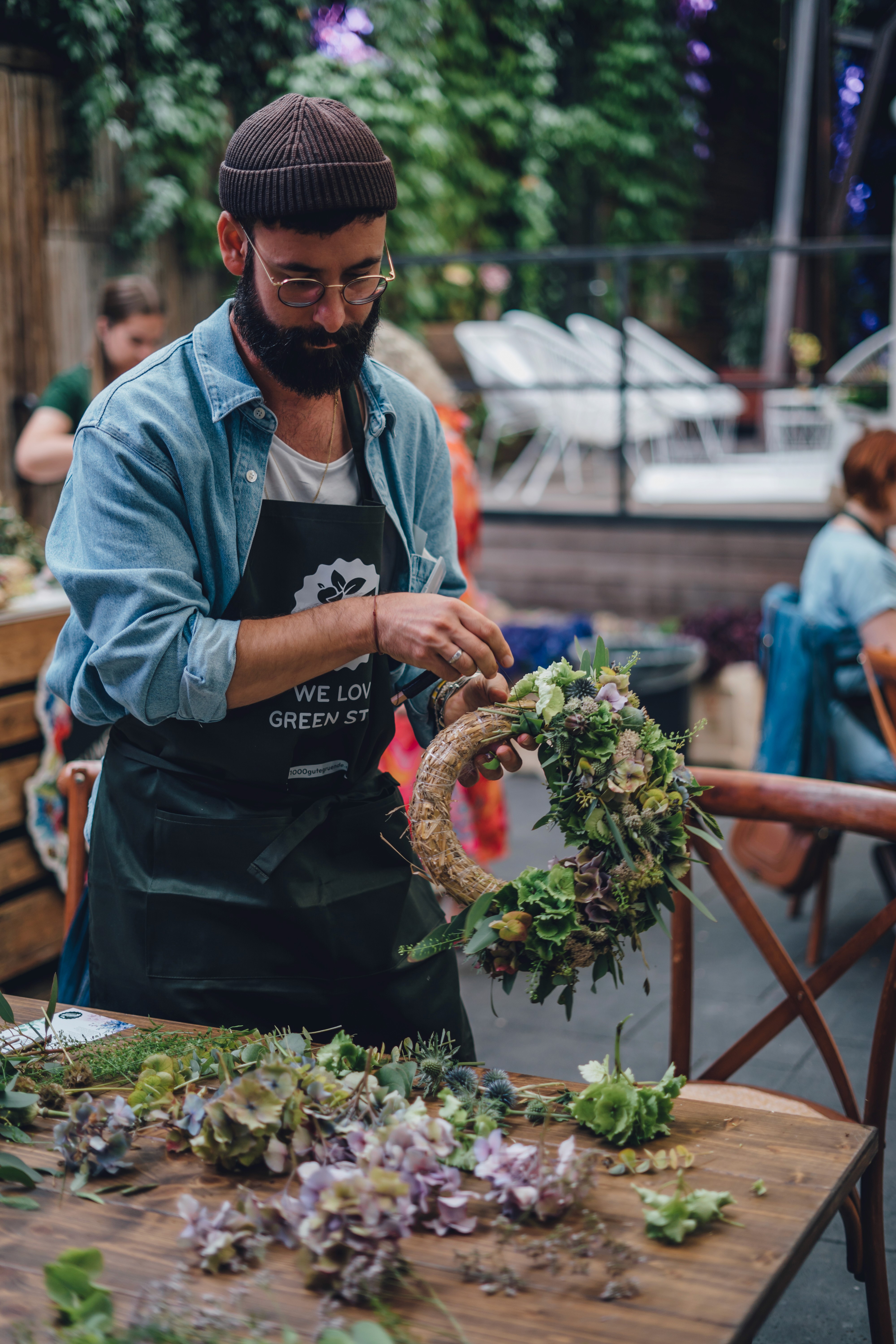 Ein Teilnehmer beim Workshop mit 1000 gute Gründe steckt einen Blumenkrank zusammen.