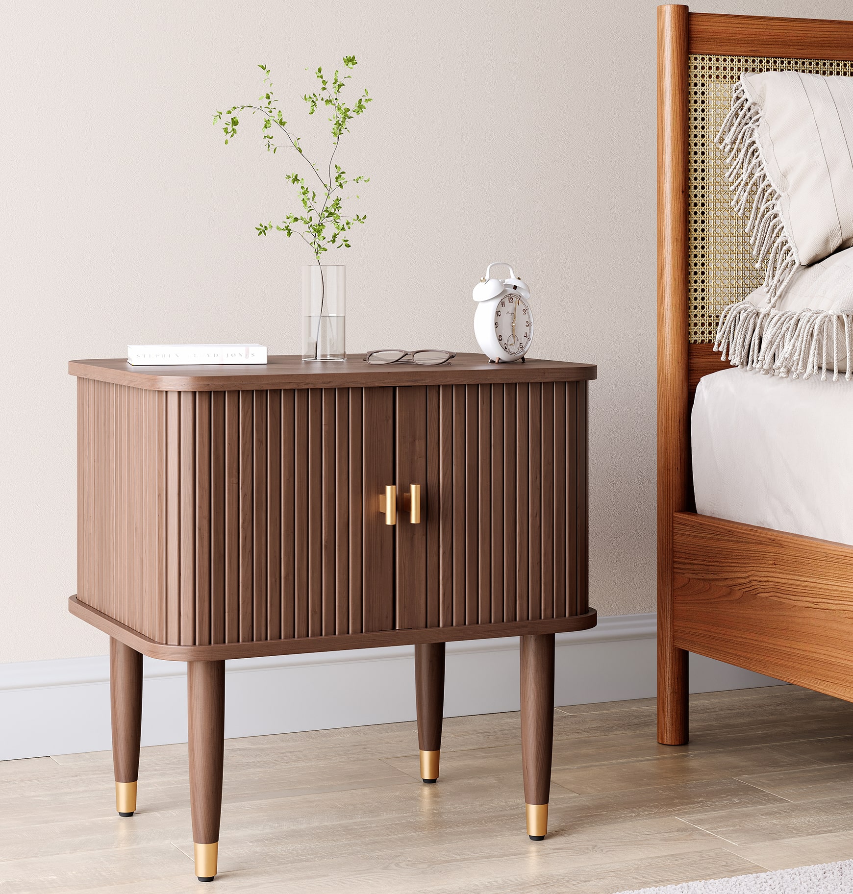 Wooden bedside cabinet with ribbed doors and brass handles next to bed in modern interior