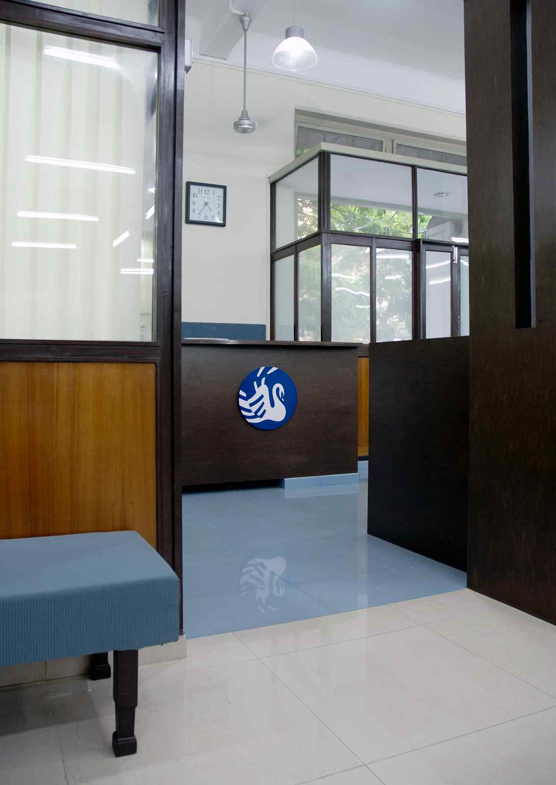 Nature-inspired preschool entrance with sculptural tree partitions and suspended green leaf ceiling panels.