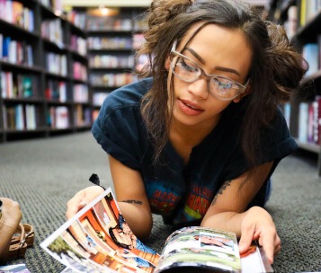 menina lendo história em quadrinhos