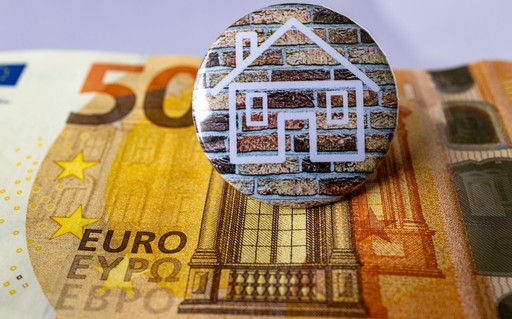 a button with a house sitting on top of a pile of money illustrating the cost of living in France