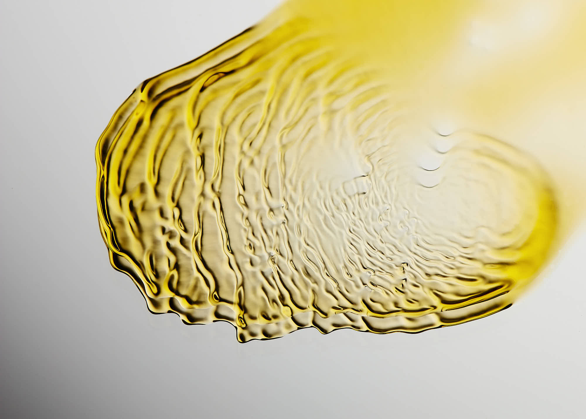 Close-up of a textured, yellowish surface resembling a slice of lemon or citrus fruit against a light background.