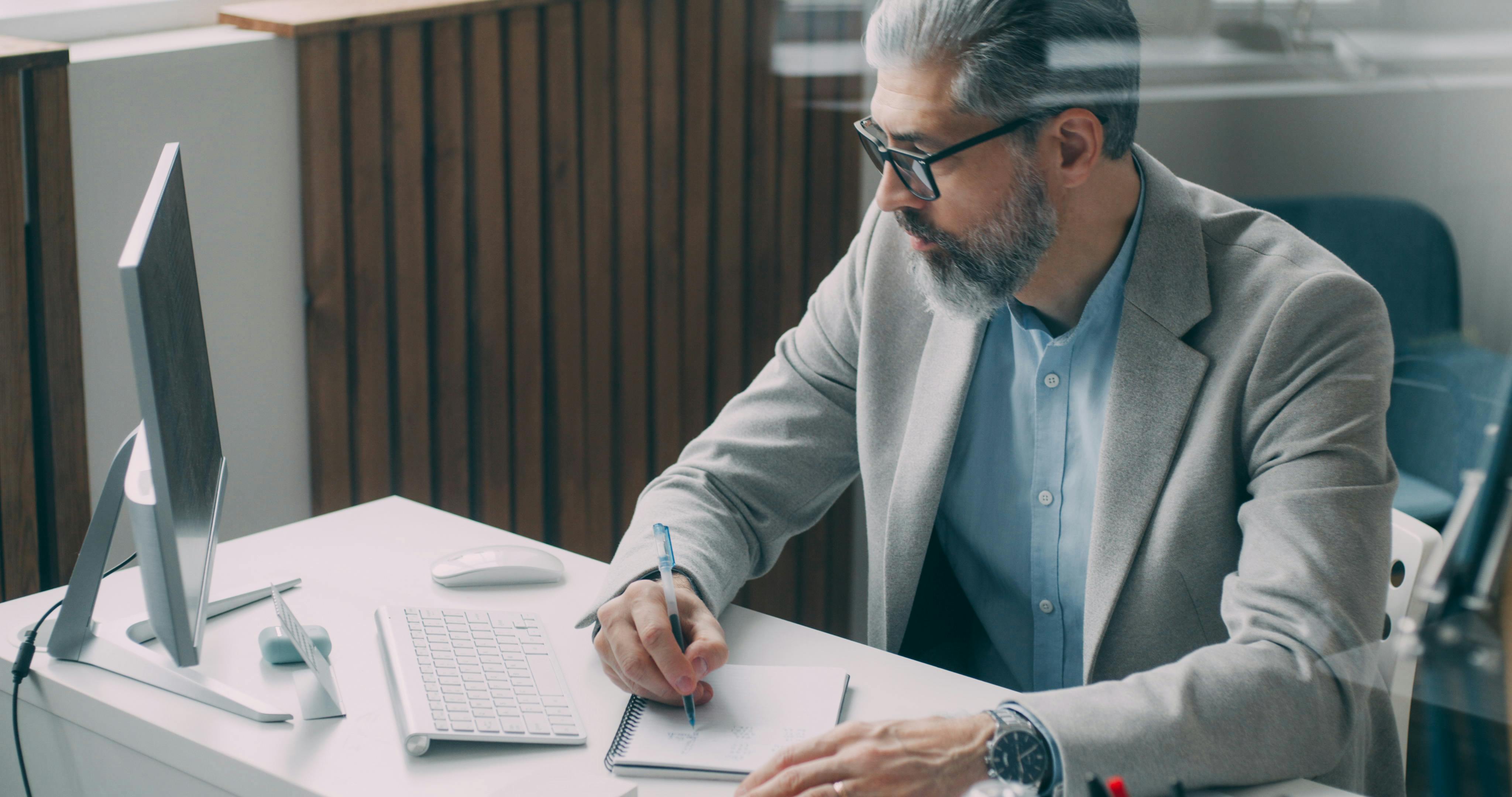 Manager prende appunti alla scrivania: pianificazione strategica e formazione executive