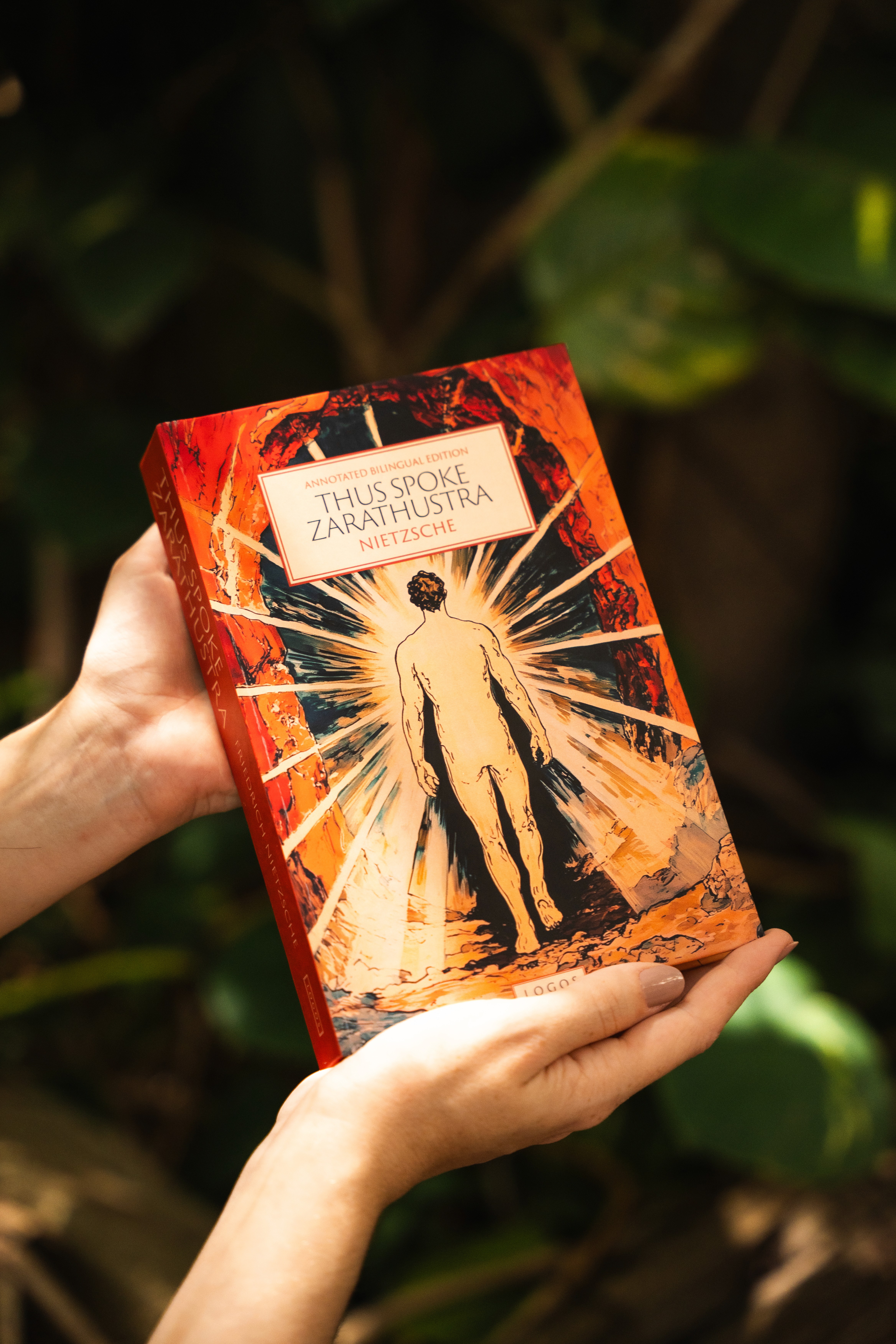 Hands holding the book The Consolation of Philosophy by Boethius, published by Logos, on a rustic wooden surface.