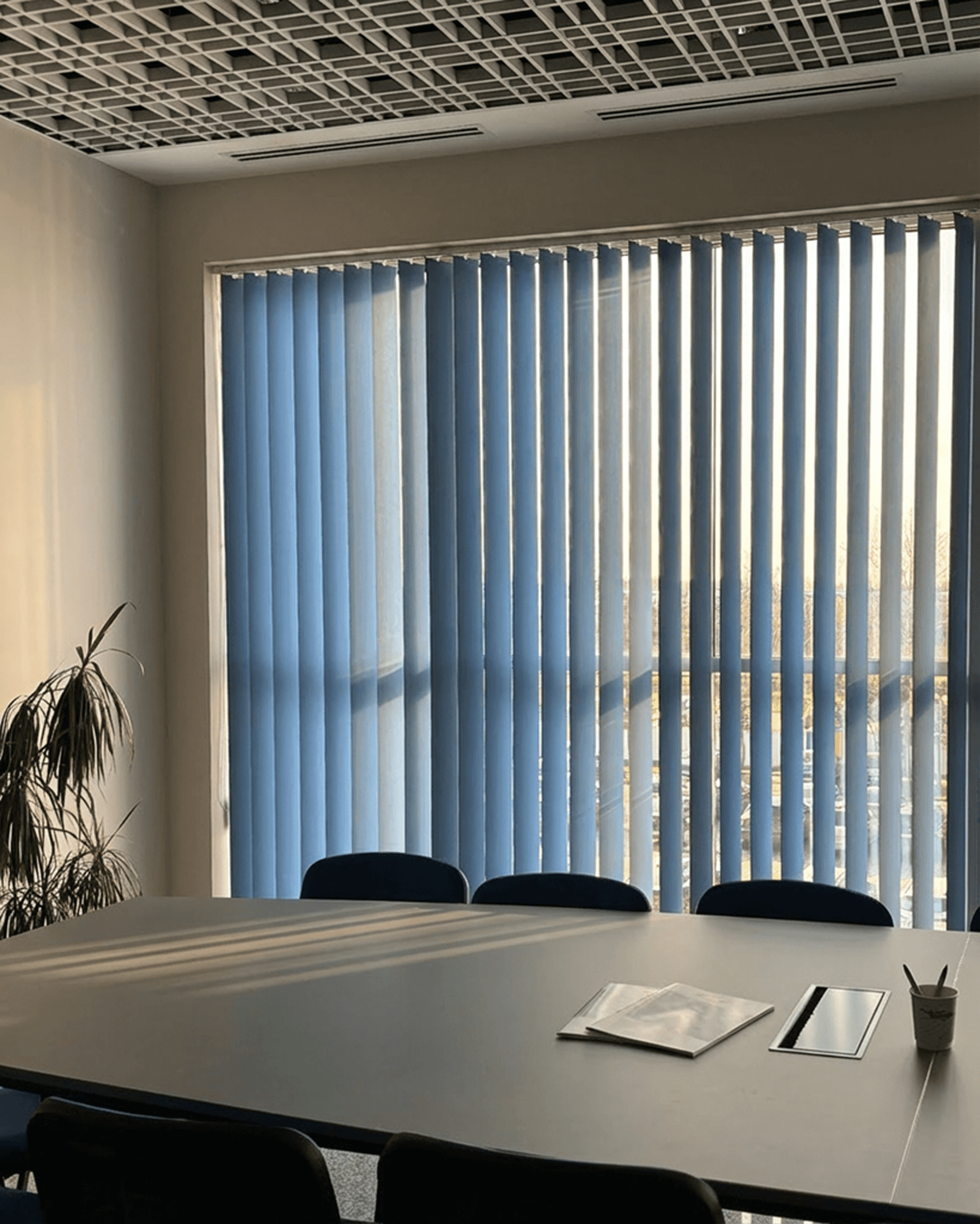Niebieskie żaluzje pionowe (verticale) w nowoczesnej sali konferencyjnej. Systemy osłon okiennych dla biur i firm od HeyShade Pruszków.